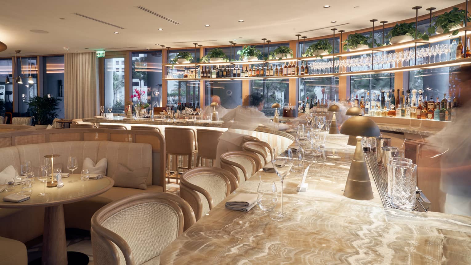 Bar with gold table and brown chairs and booths.