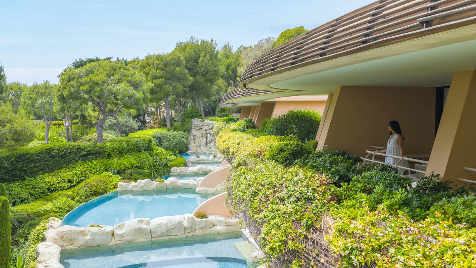 Aerial view of hotel room terrace, overlooking gardens and private pools