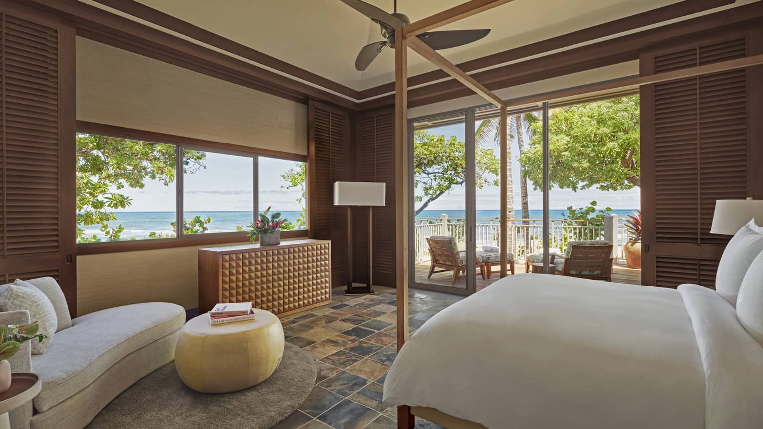 Kailani Suite opening onto veranda with King bed, white linens, cream chaise lounge