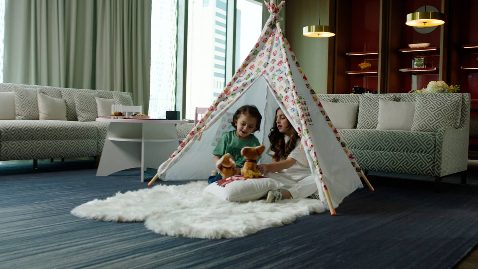 Young girl and boy play in in-room tent in Amiri Suite living area