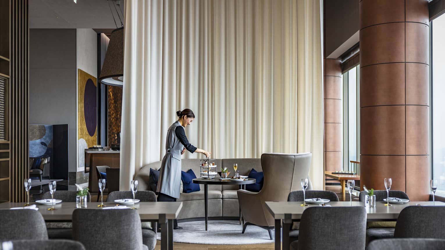 Female staff member sets tables at The Lounge