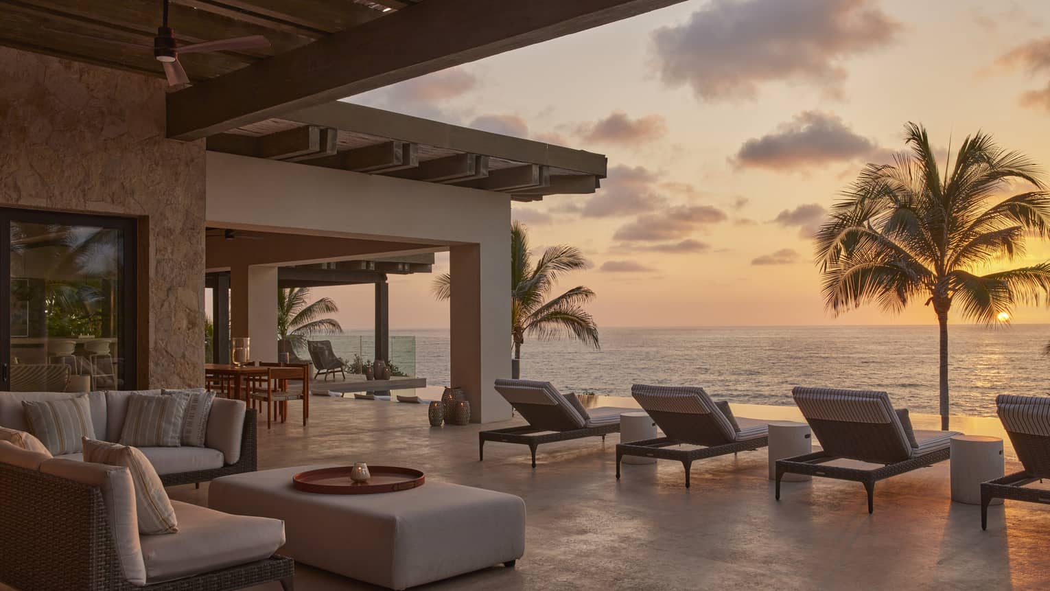 Private villa pool deck with ocean view at sunset