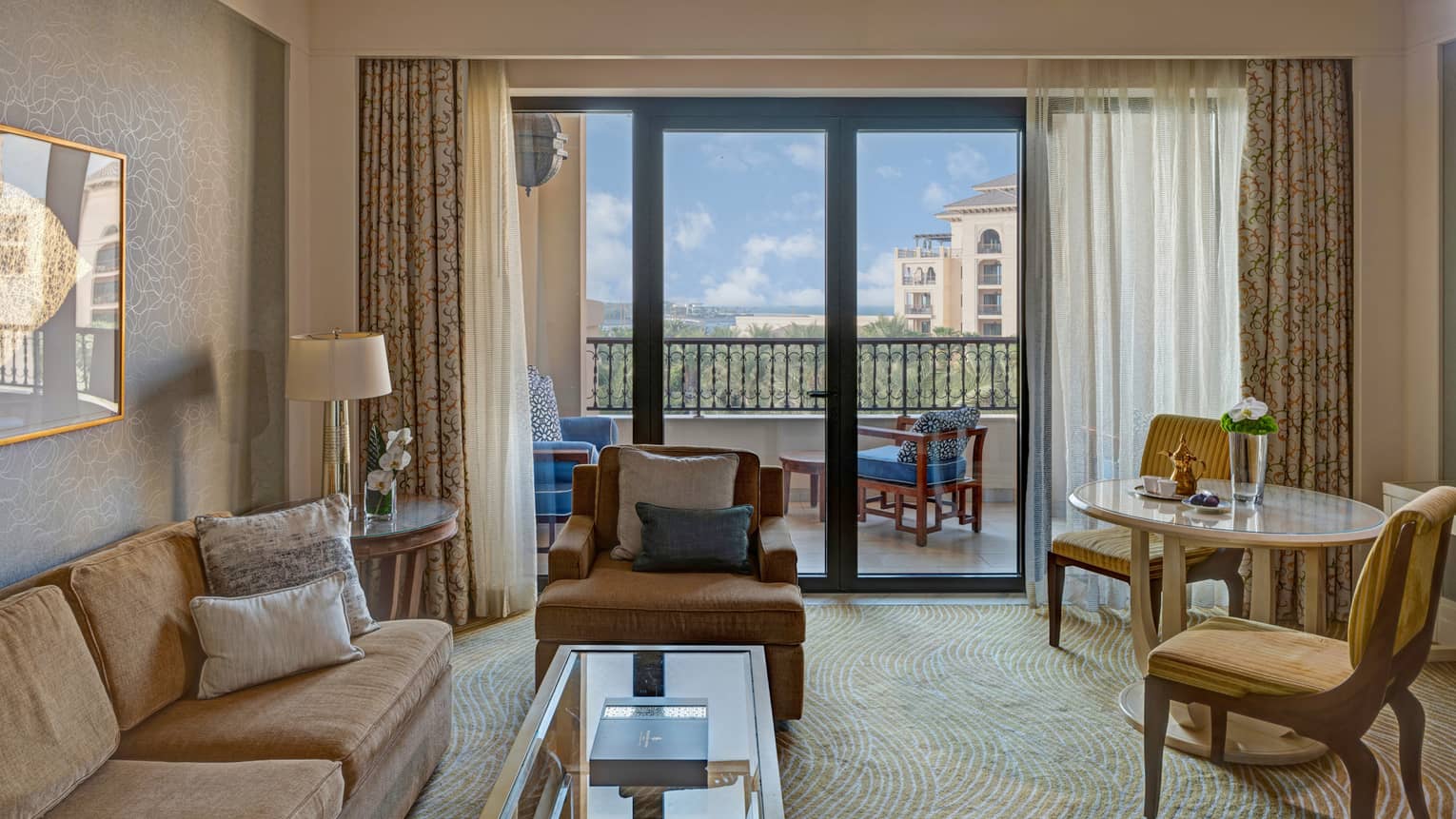 Living room with light brown sofa, arm chair, round table and chairs