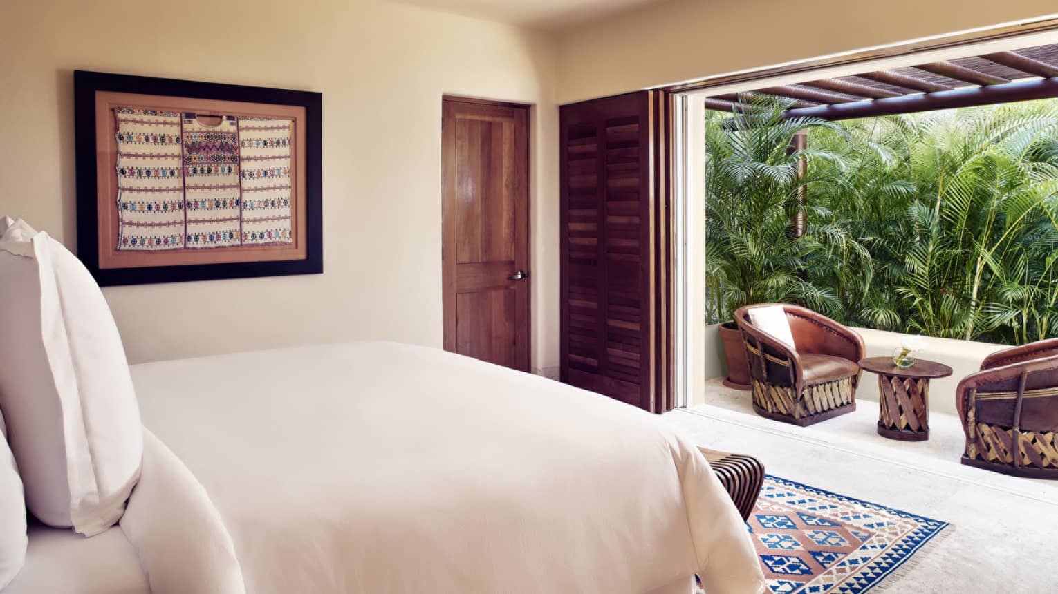 Bedroom with king bed and walk-out terrace with palm trees