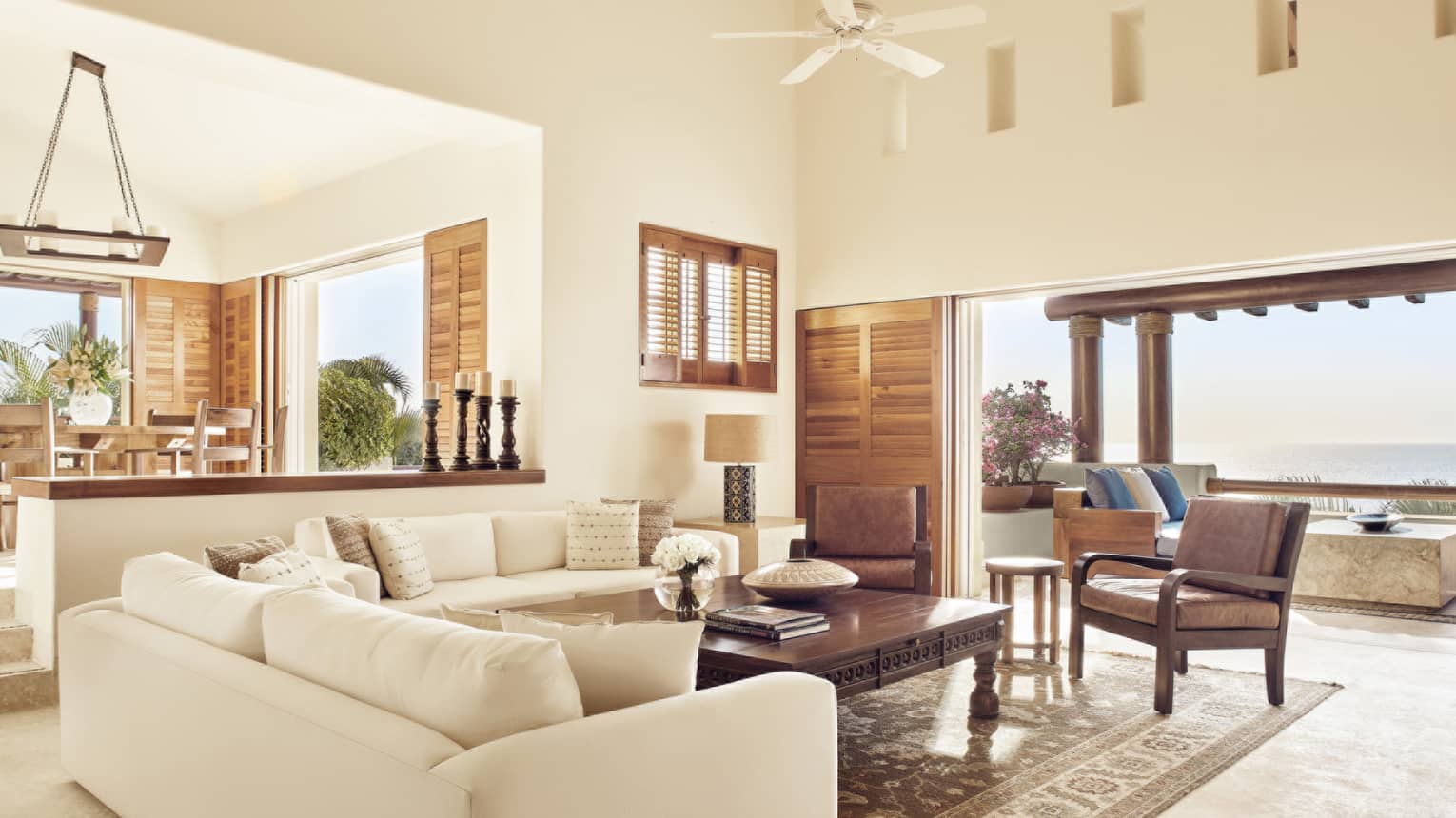 Living room with two white sofas and walk-out ocean-view terrace