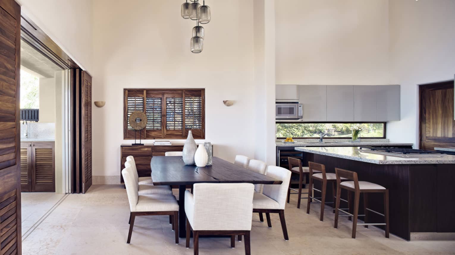Kitchen and dining room with large wooden table and 8 white upholstered chairs