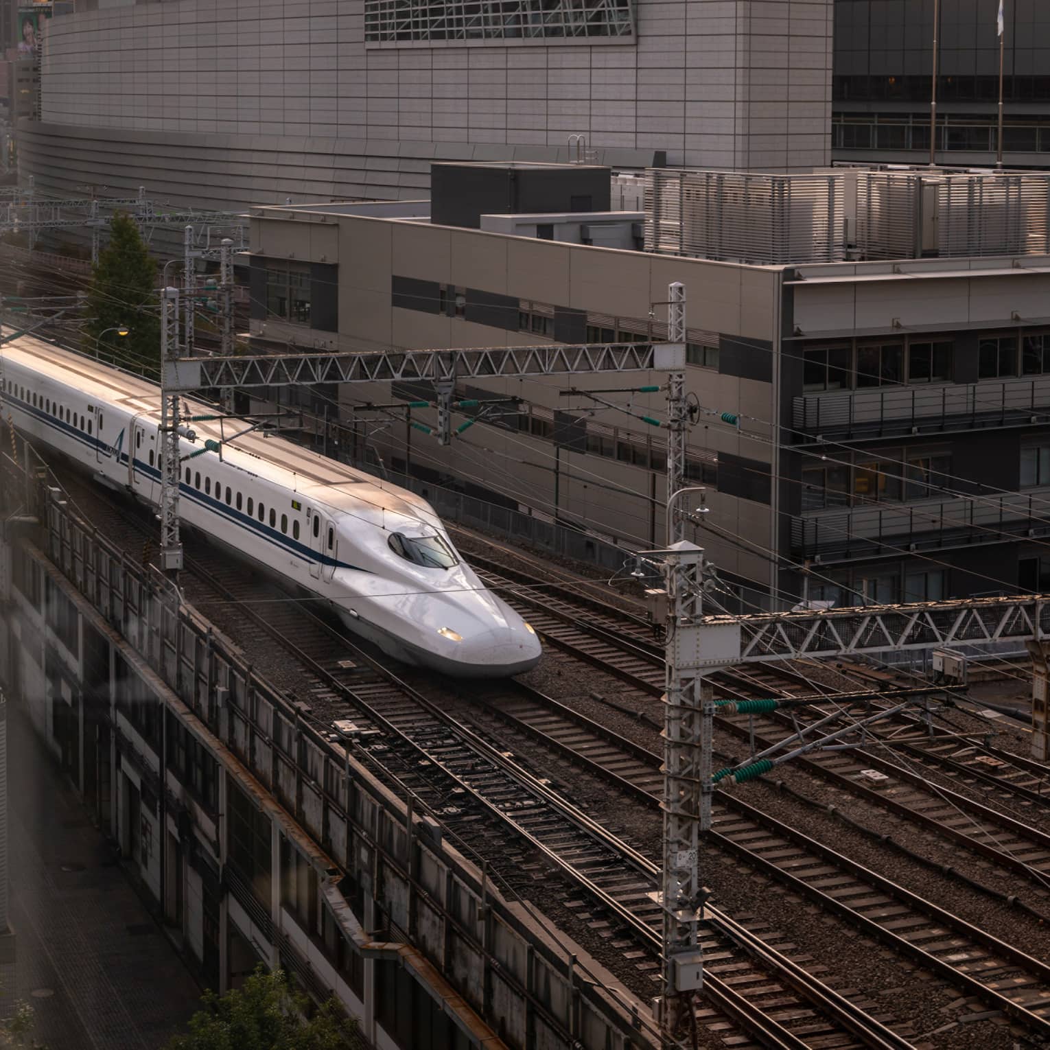 Shinkansen bullet train arrives at the station at sunset