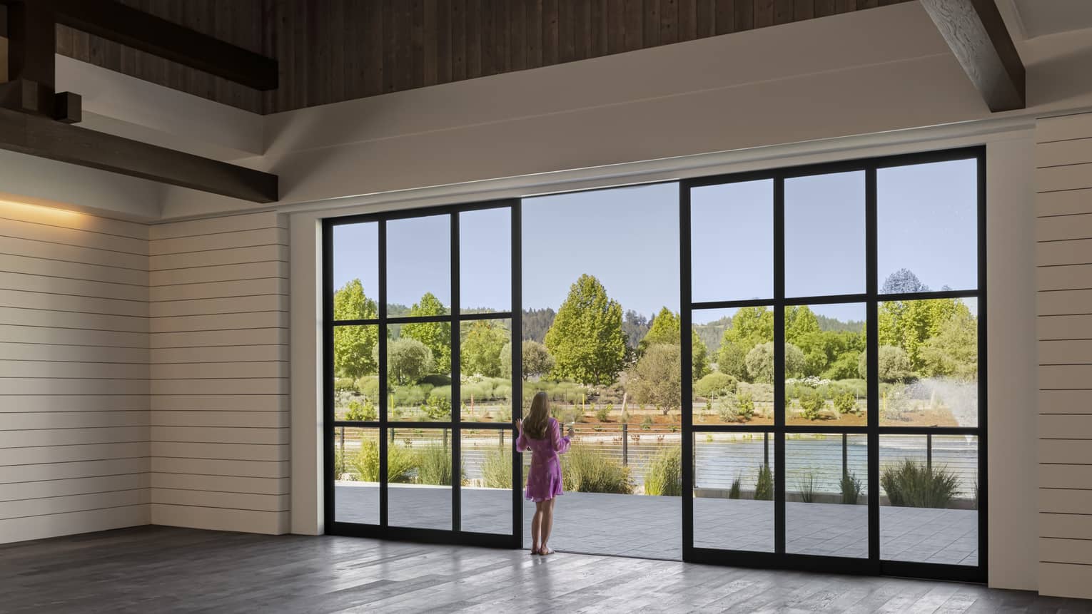 Rustic venue space with multi-light modern chandelier, walk-out glass doors