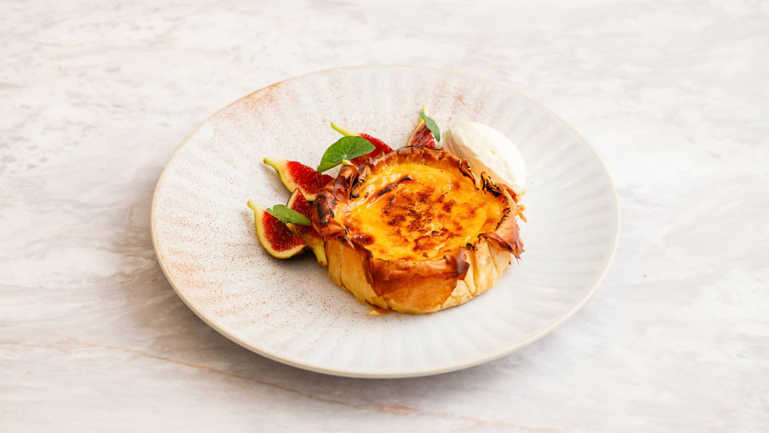 Pastel de Nata made with vanilla custard and cinnamon and served with scoop of lemon ice cream and fig slices