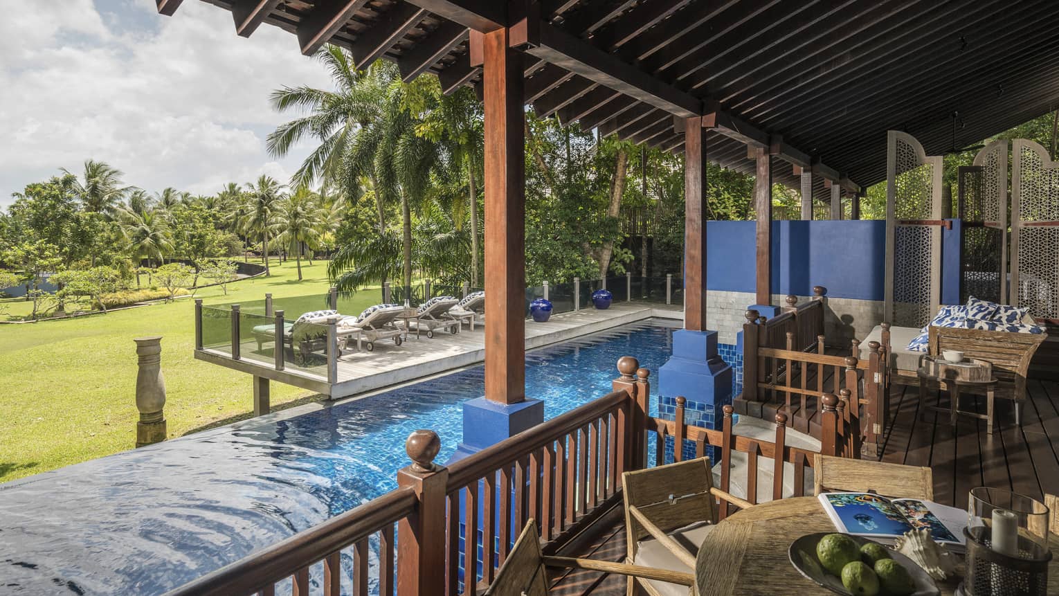 Three Bedroom Villa outdoor terrace with view of the lawn and an infinity-edge pool