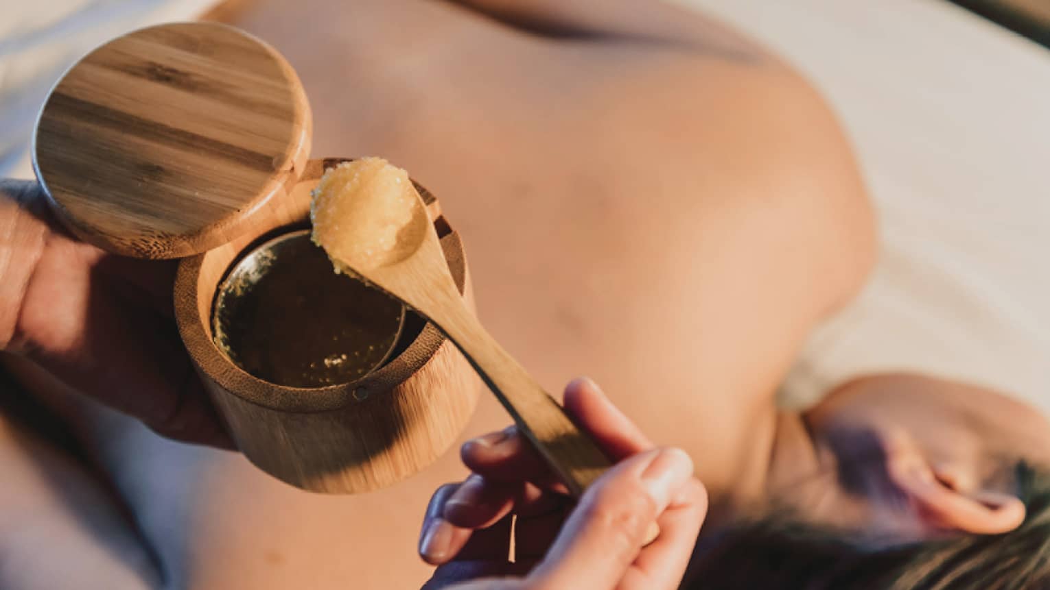 A spa scrub is placed on a guest's back during a relaxing treatment