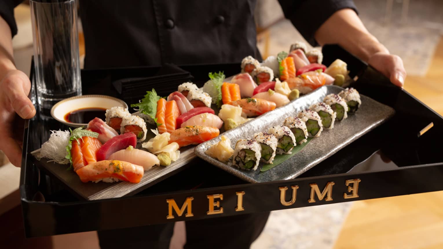 Restaurant server holds tray with Mei Ume Sushi Canapes on platters