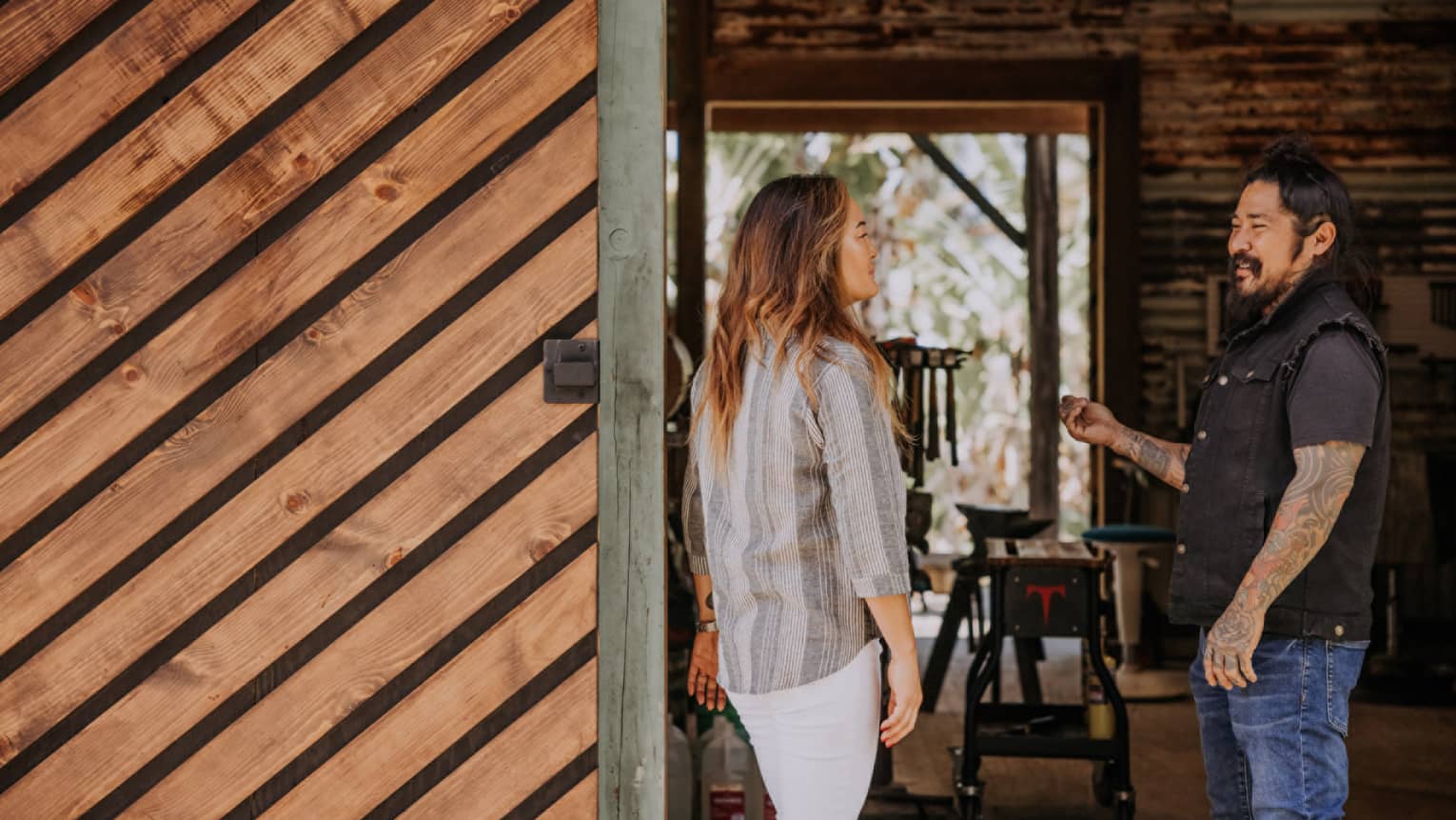 A woman talks to a blacksmith at his Hawaii Island studio