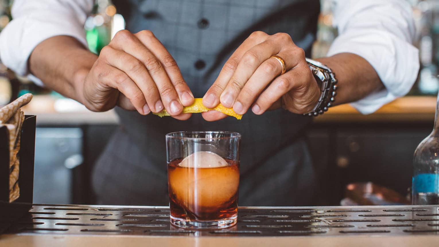A bartender garnishing a cocktail.