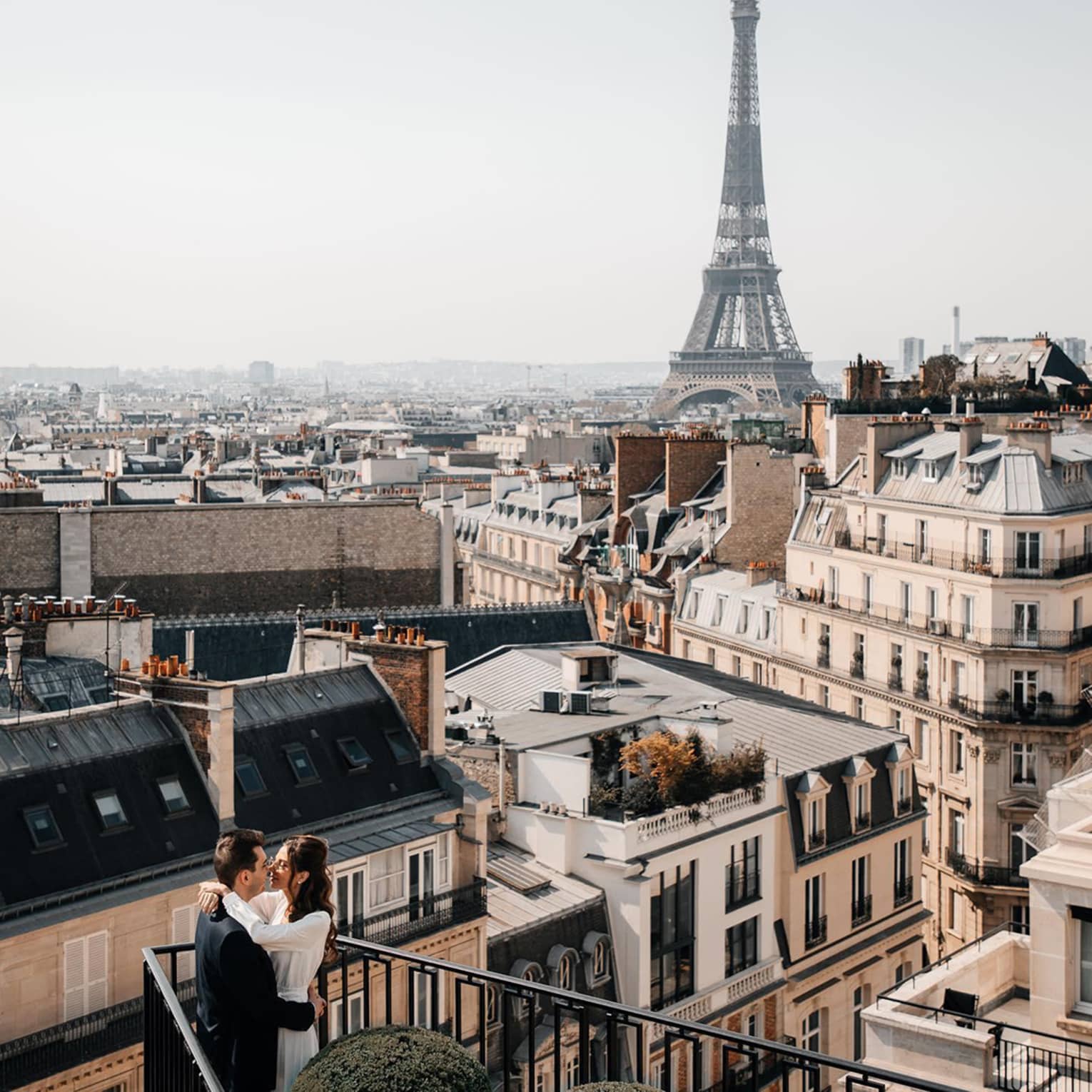 Couple embracing on Paris Hotel terrace with Eiffel Tower view