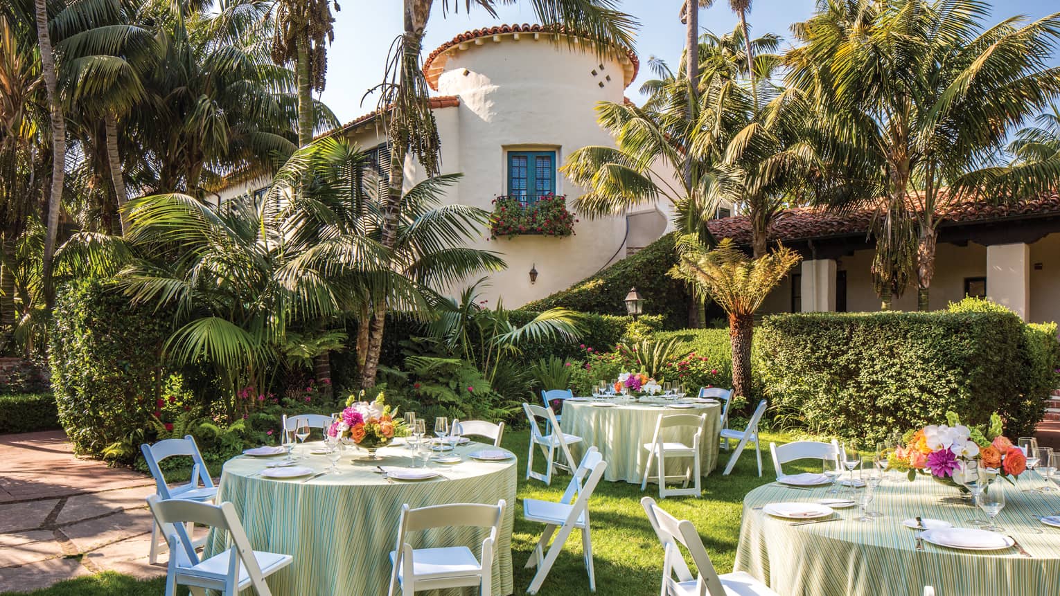 Escala Garden banquet tables on lawn under palm trees 