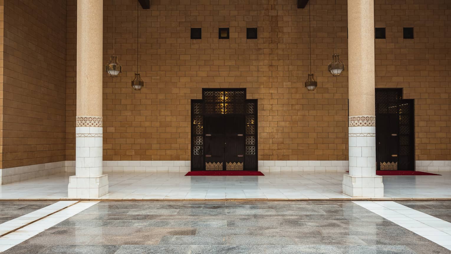 A brown stone wall with grey tile flooring.