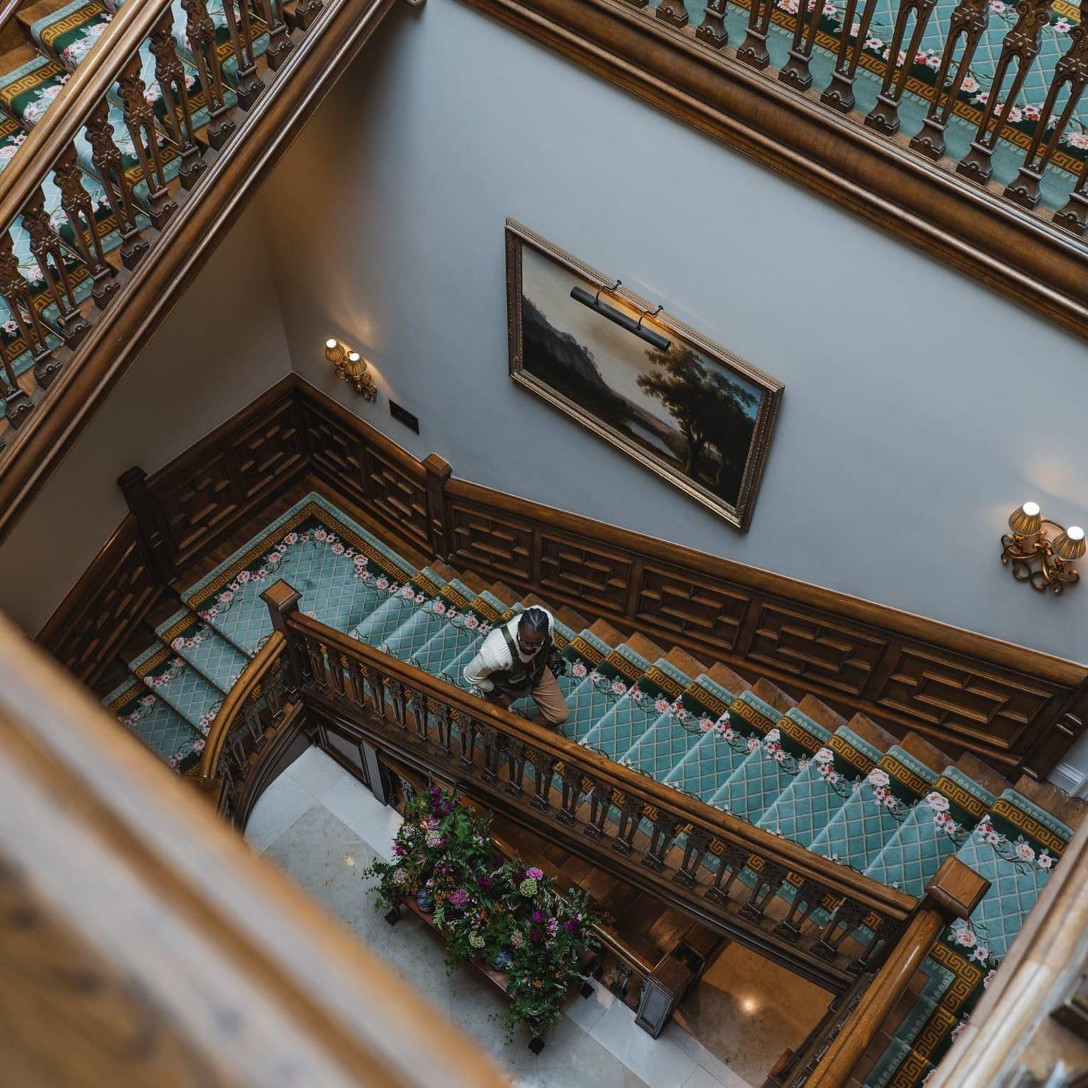 Aerial view of a  man ascending a spiral wooden staircase