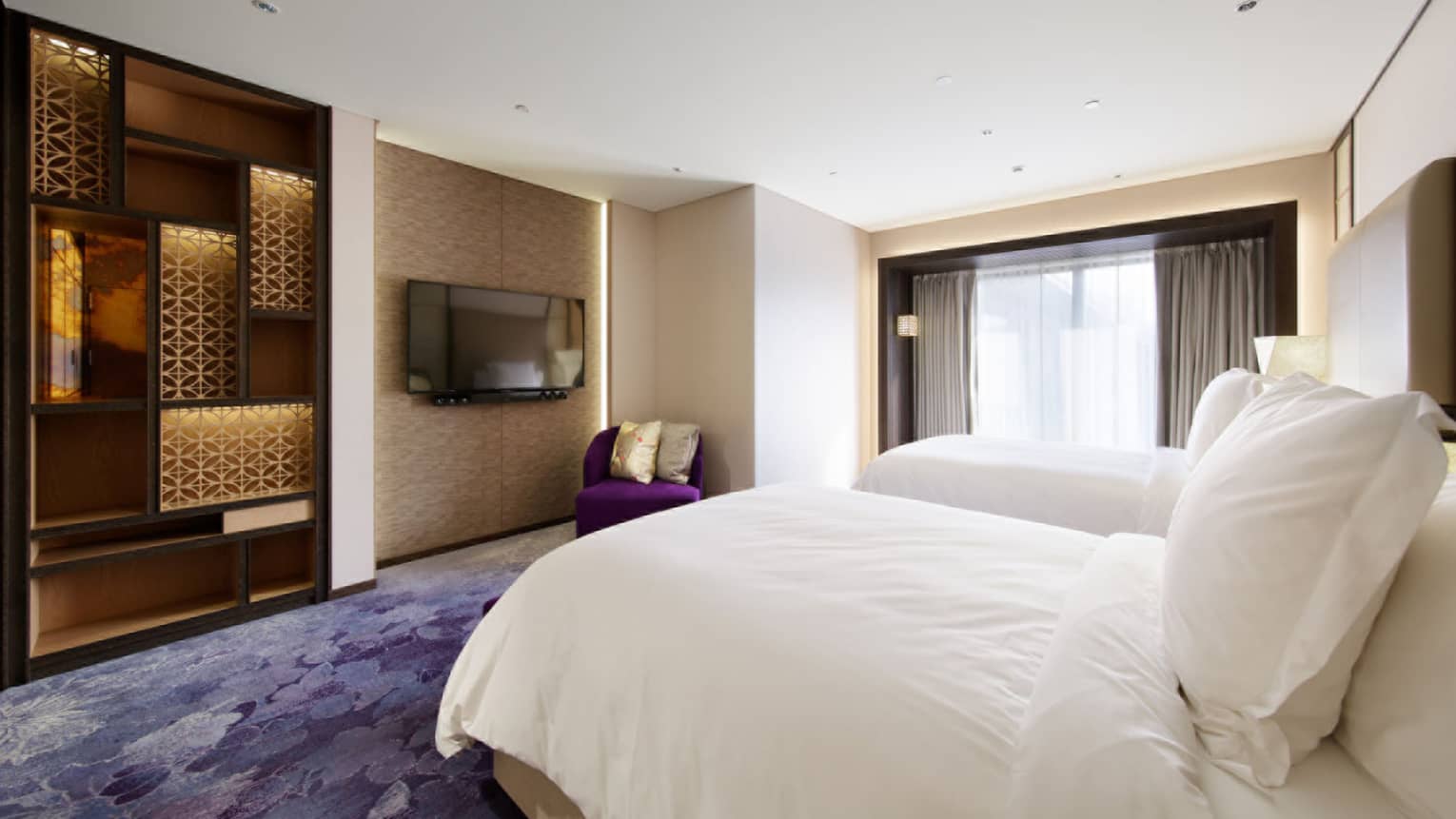One Bedroom Suite bedroom with twin beds, built-in bookshelves, corner armchair, wall-mounted TV, doorway to terrace