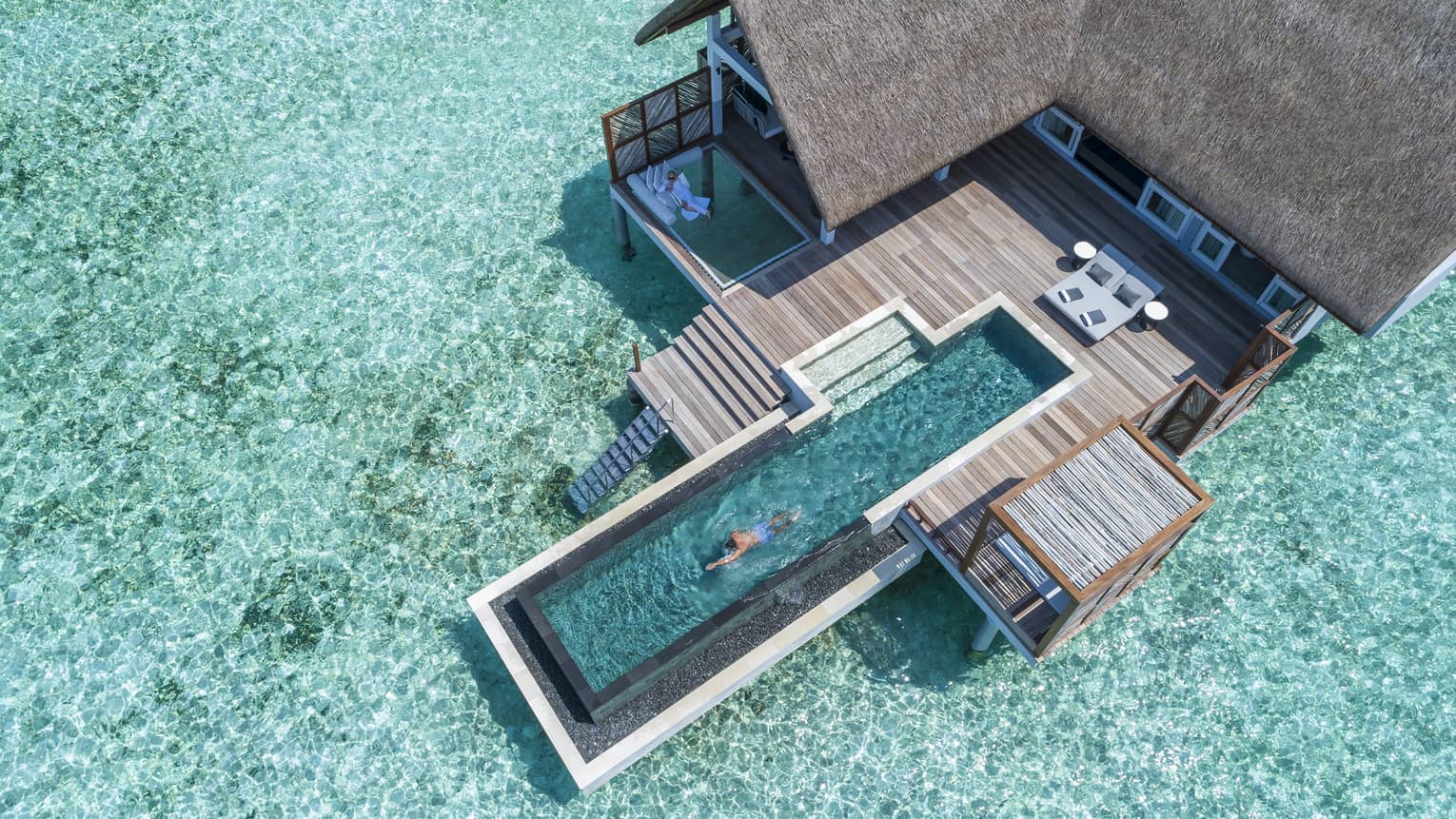 Aerial view of water villa with long swimming pool over lagoon