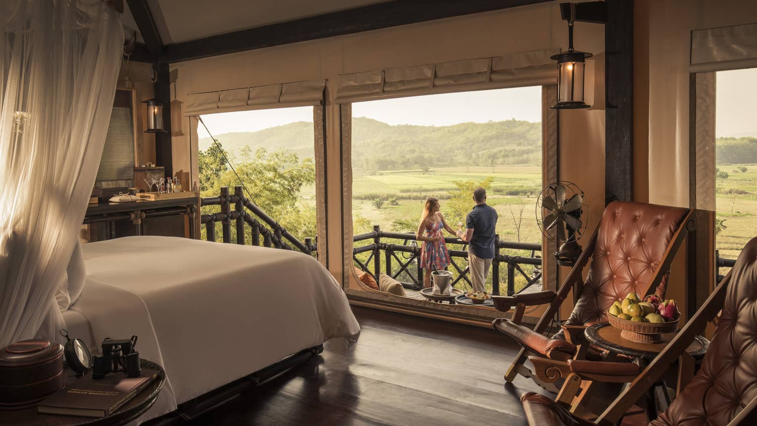 Couple enjoys cocktails overlooking fields and mountains