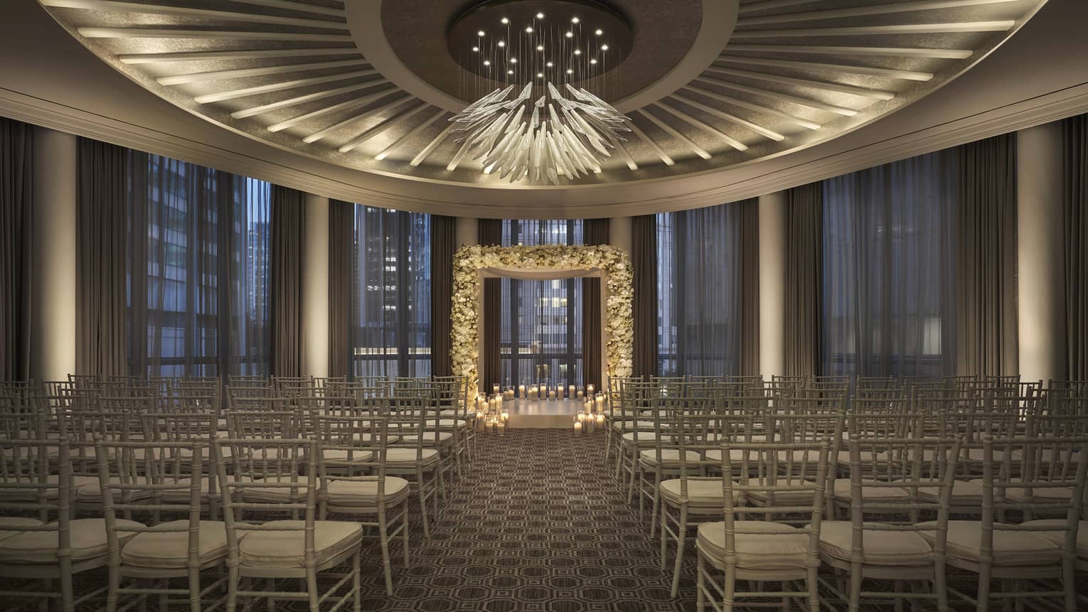 An empty Clarendon Room, but all set up for a wedding reception, with a lit-up altar and rows of seats