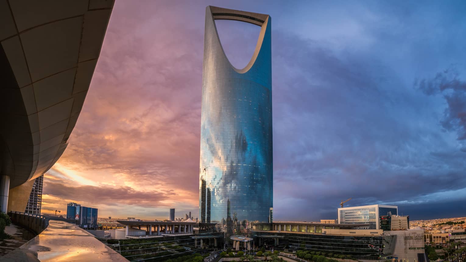 Looking up at modern Four Seasons Hotel Riyadh at Kingdom Centre tower skyscraper at sunset