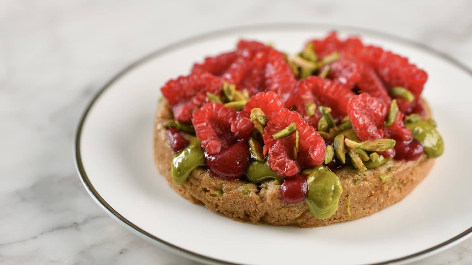 Raspberry-Pistachio Cookie topped with fresh halved raspberries and chopped pistachios
