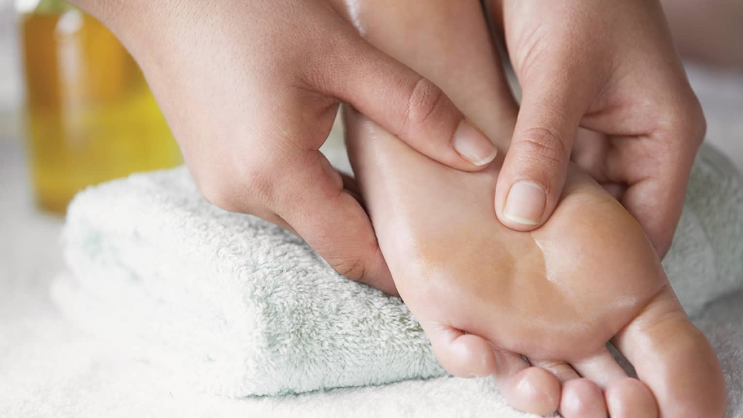 Close-up of hands massaging pressure points on feet