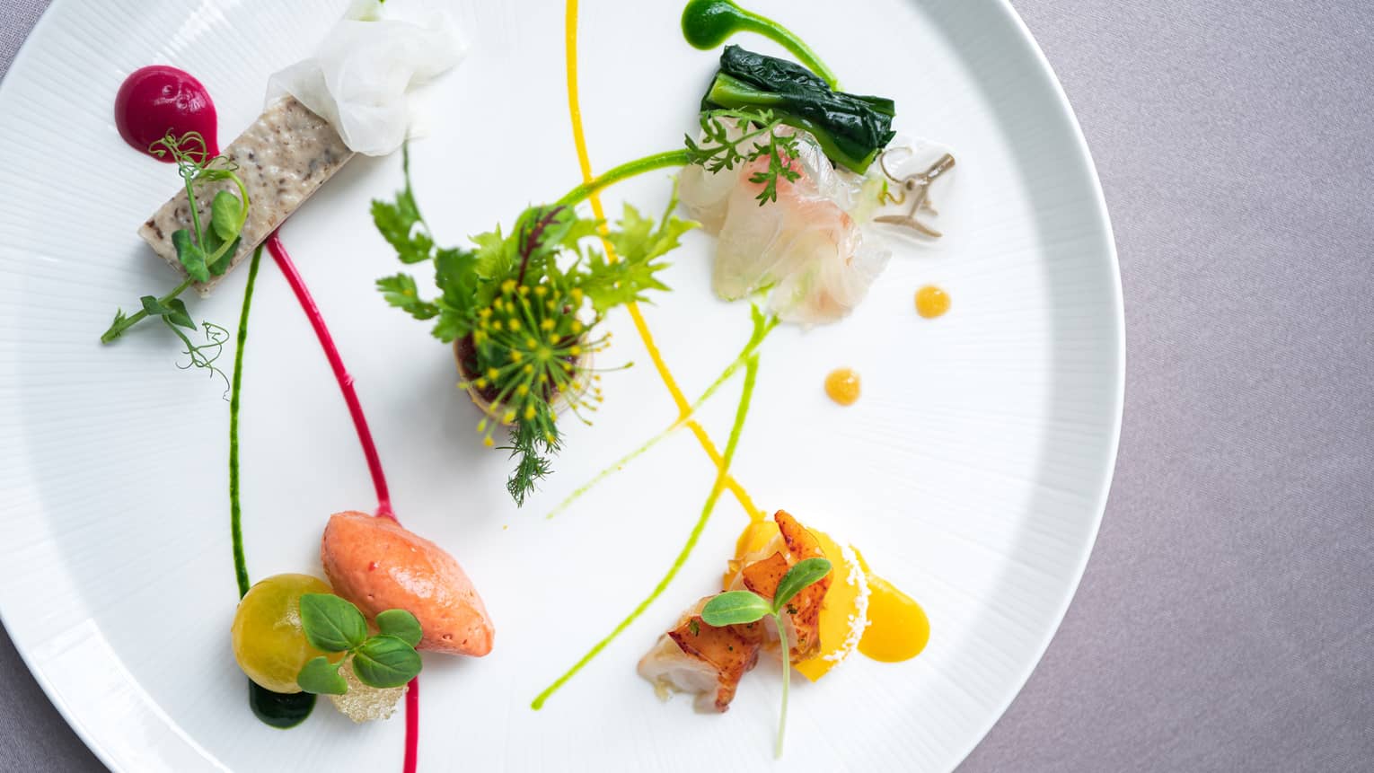 Small appetizers arranged on plate with artistic garnish