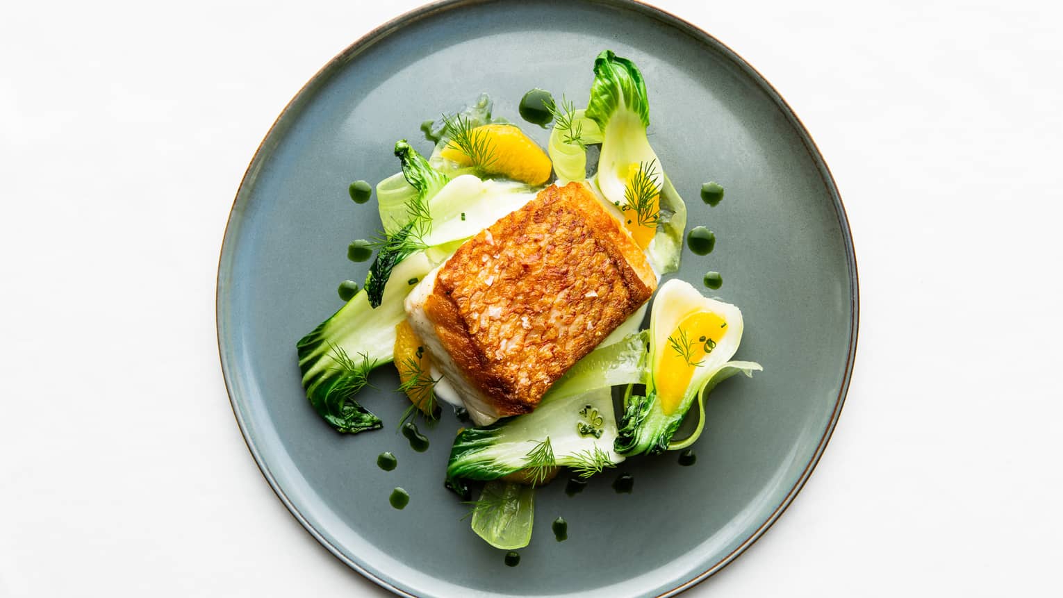Aerial view of Florie's Seared Snapper Fillet on bed of bok choy and orange slices