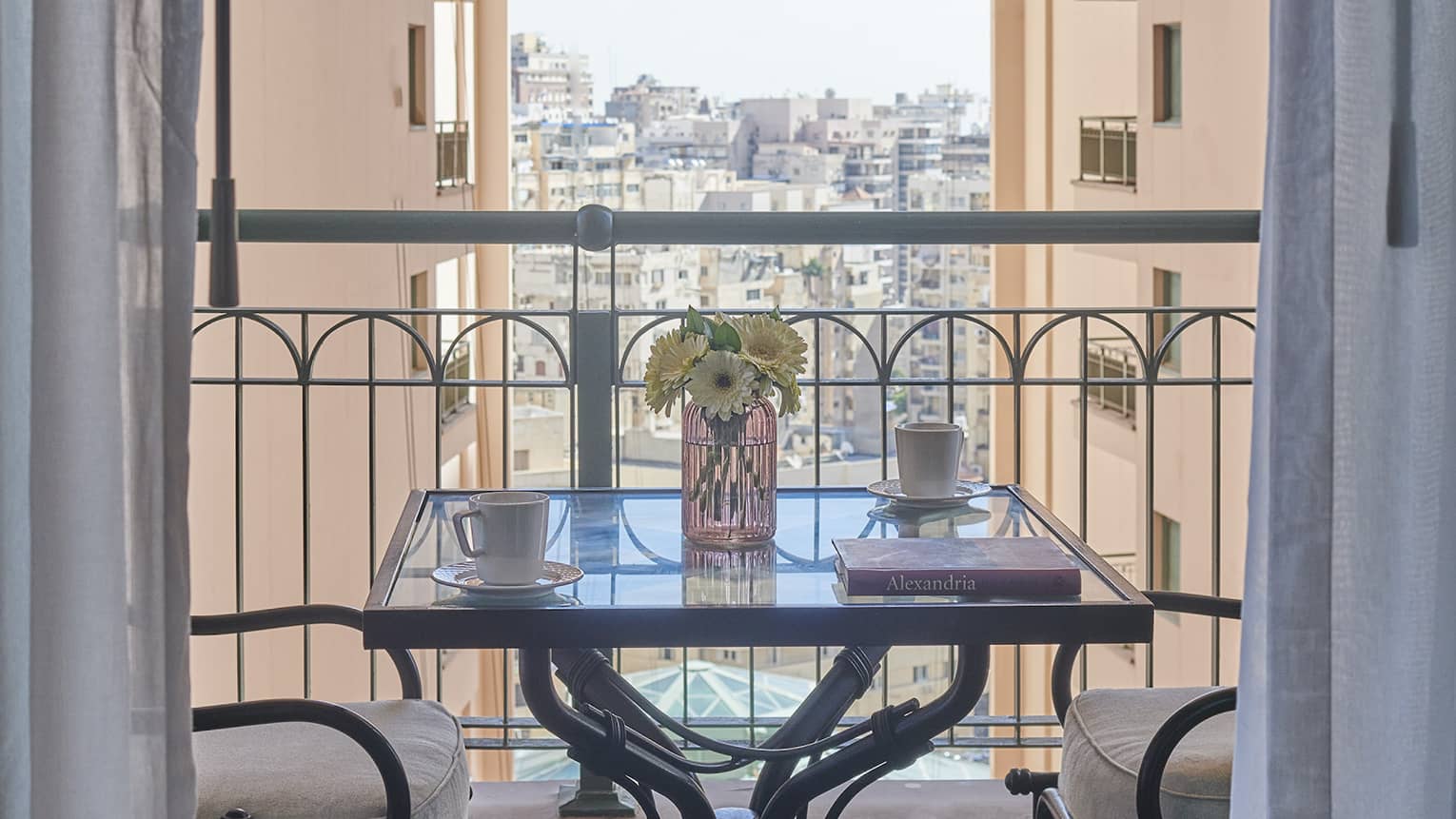 Veranda with two-seater square table, views of cityscape