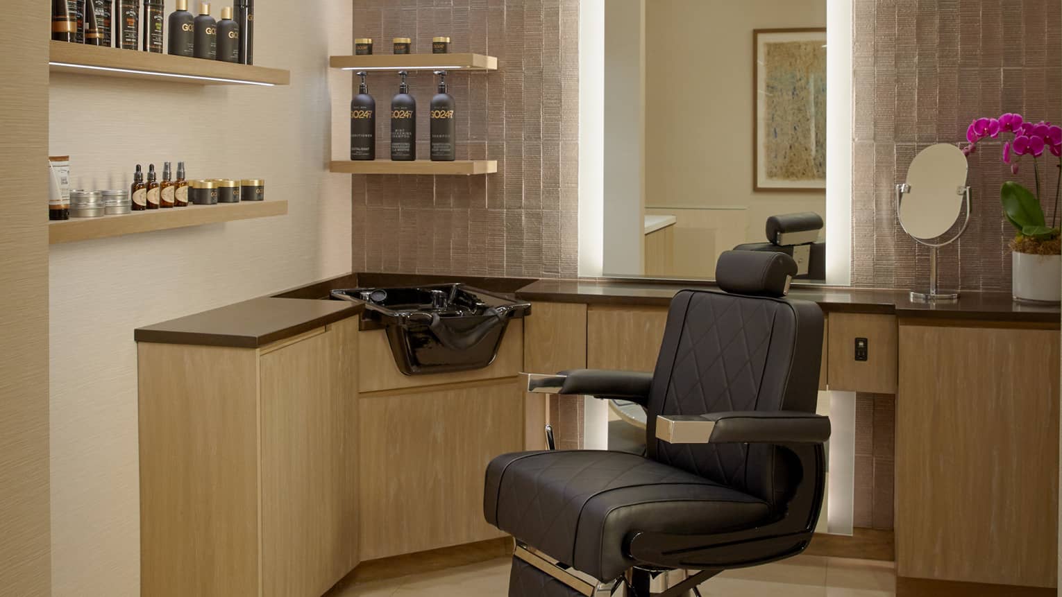 A salon chair next to a sink and shelves of hair products