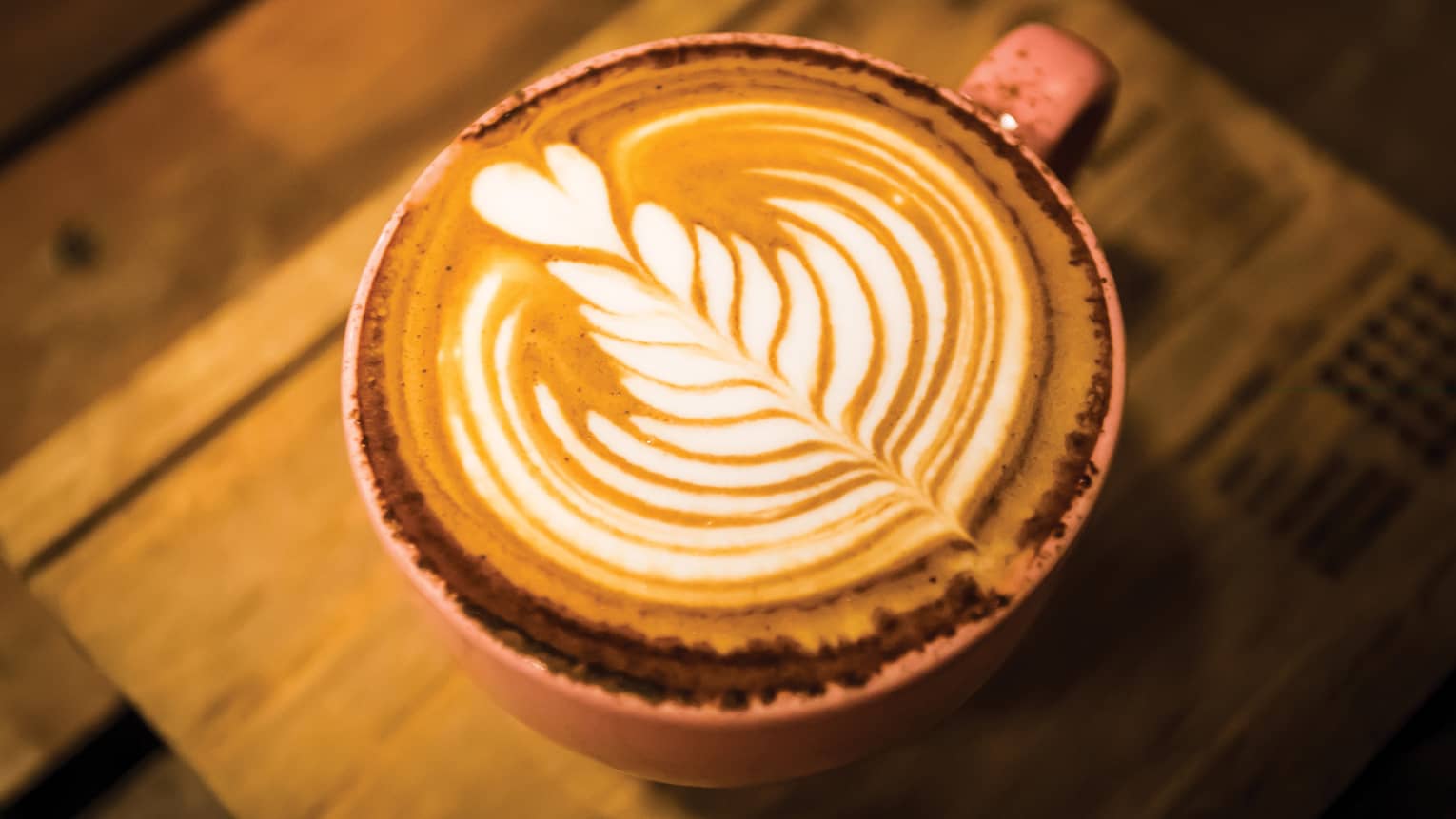 Close-up of latte coffee with flower design in foam