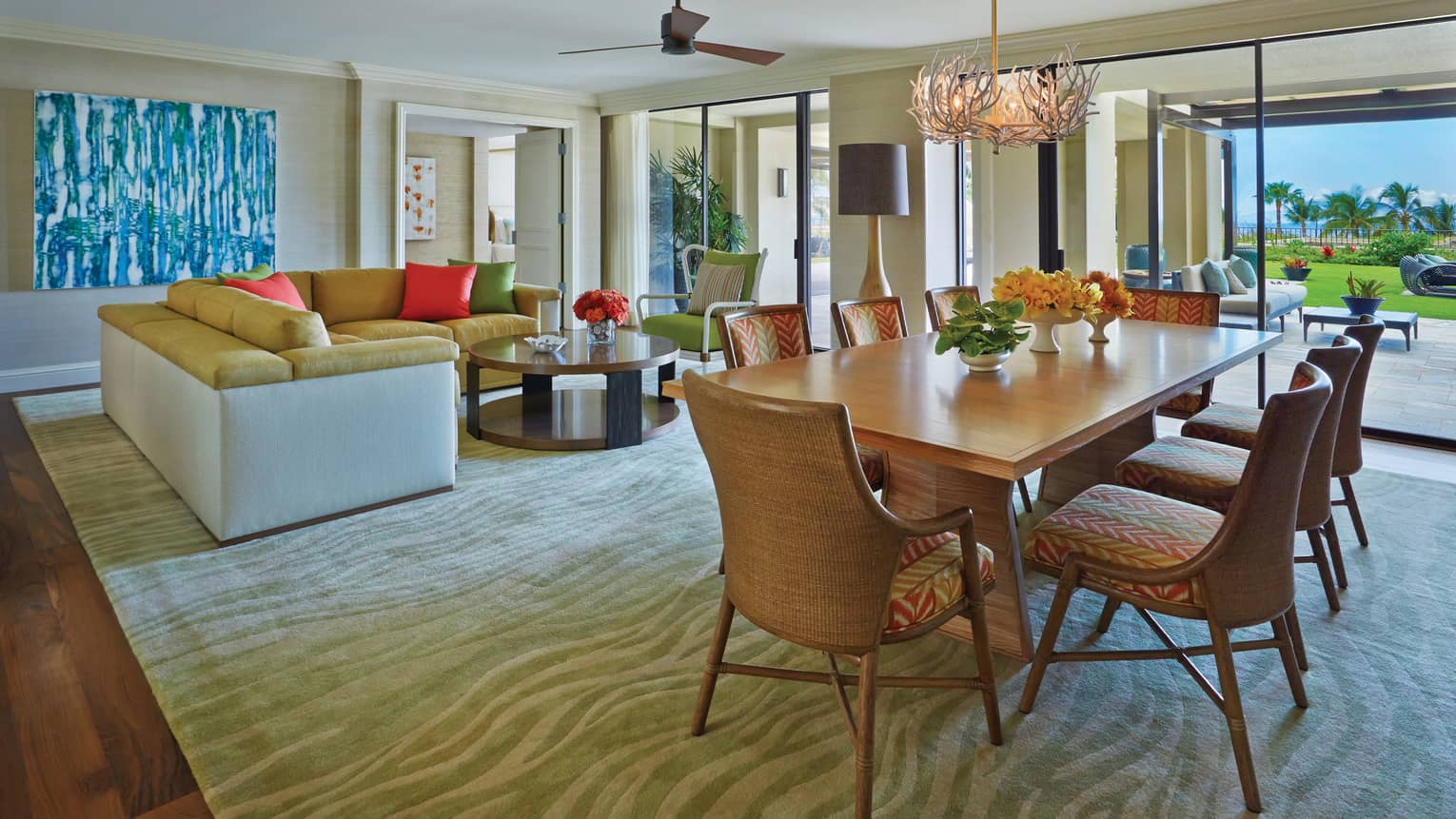 Spacious open-plan living and dining area with modern furnishings, large windows and garden view