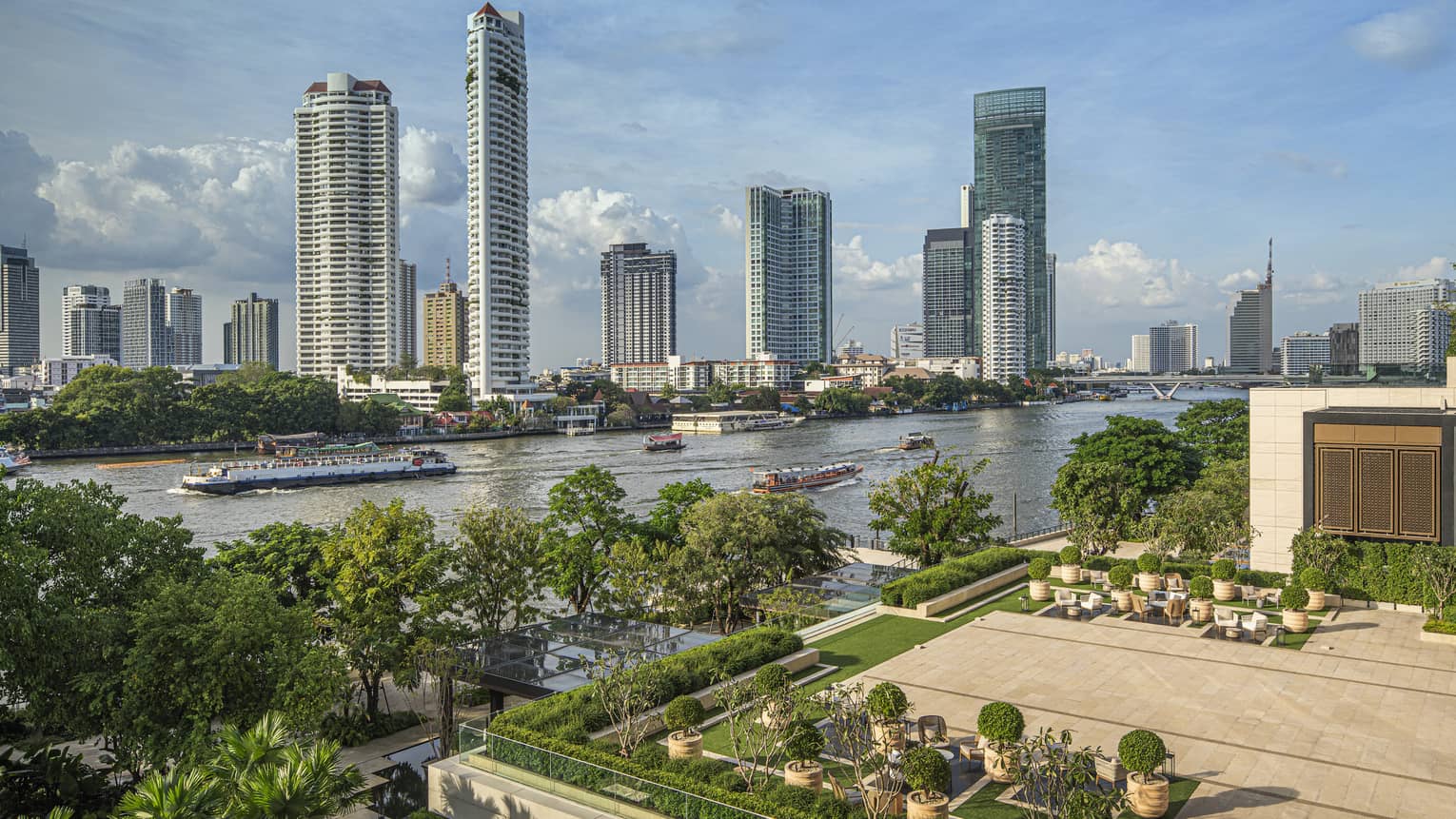 Outdoor terrace with landscaping around edge, view of Chao Phraya River in Bangkok