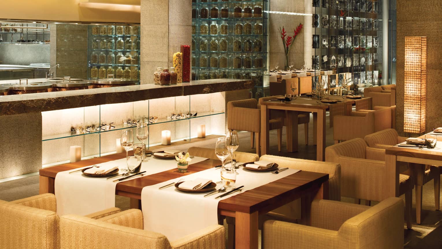 San Qi dining room, modern wood table with white runners, counter, glass wall with spices
