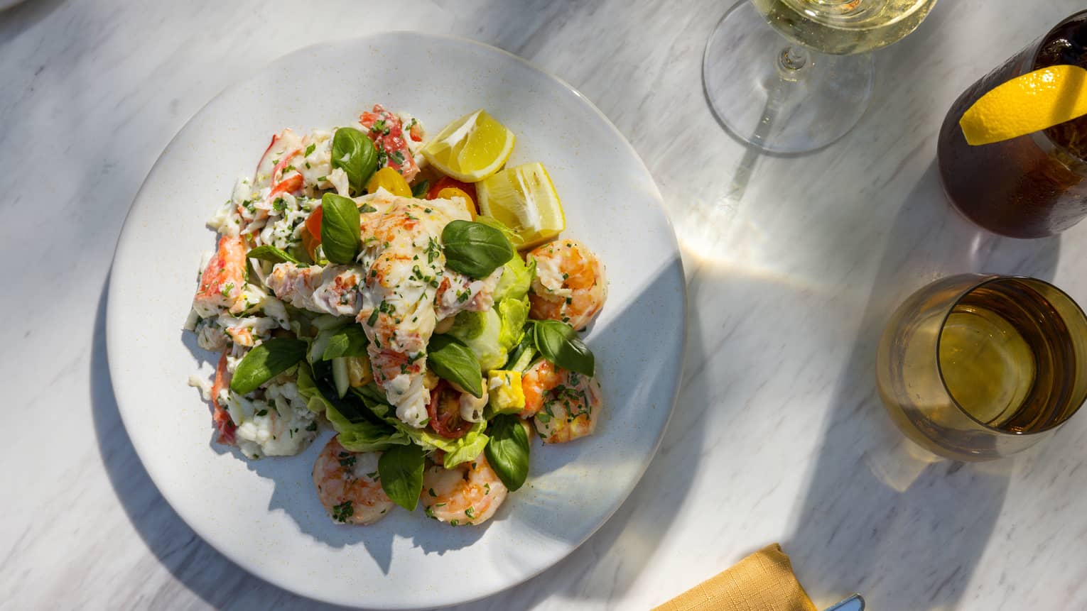 Shrimp with greens, lemon, and a glass of wine.
