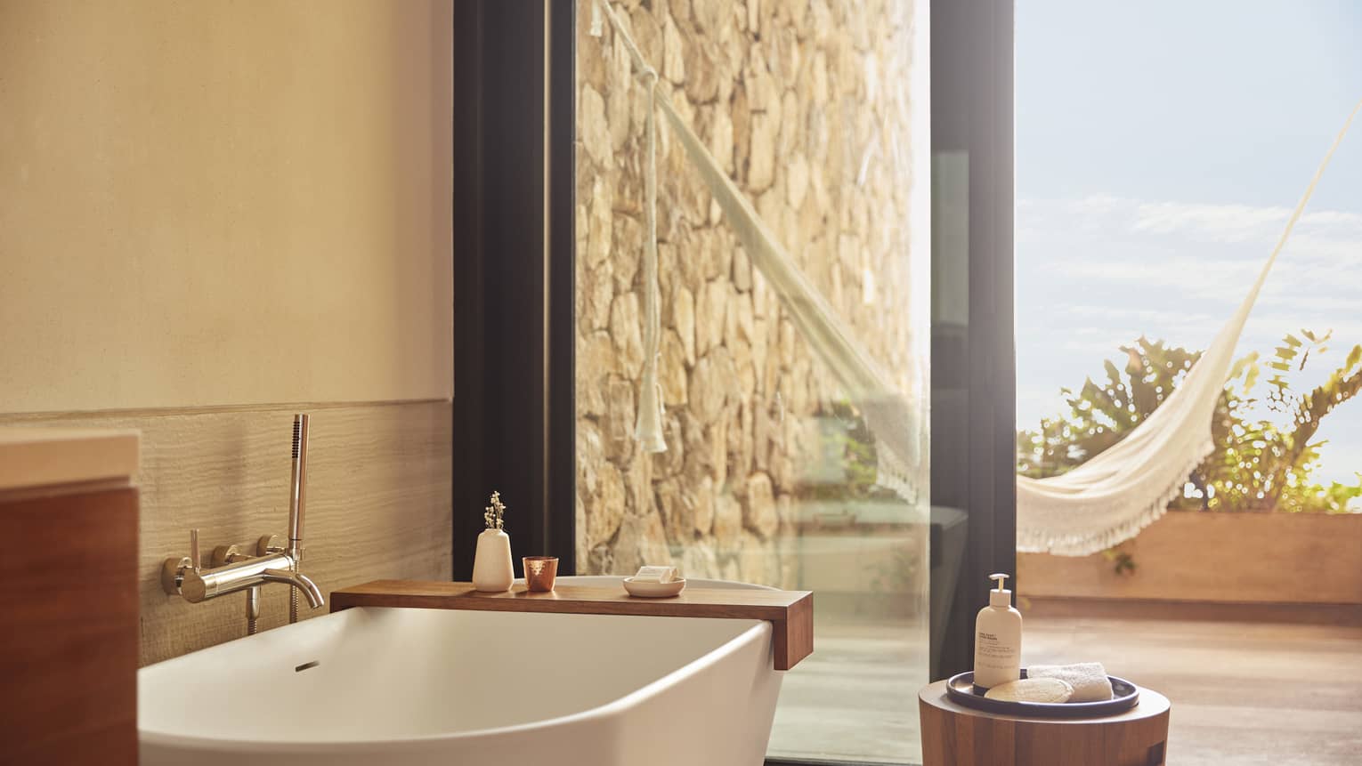 The bathroom of a beachfront room, with a large window looking outside.