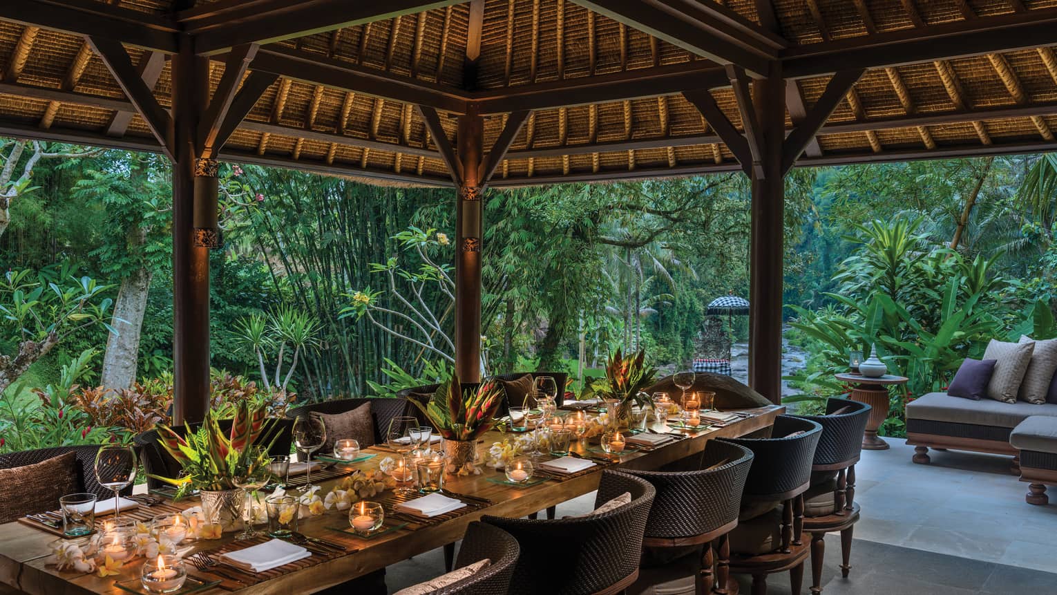 Long private dining table with candles under Royal Villa outdoor pavilion