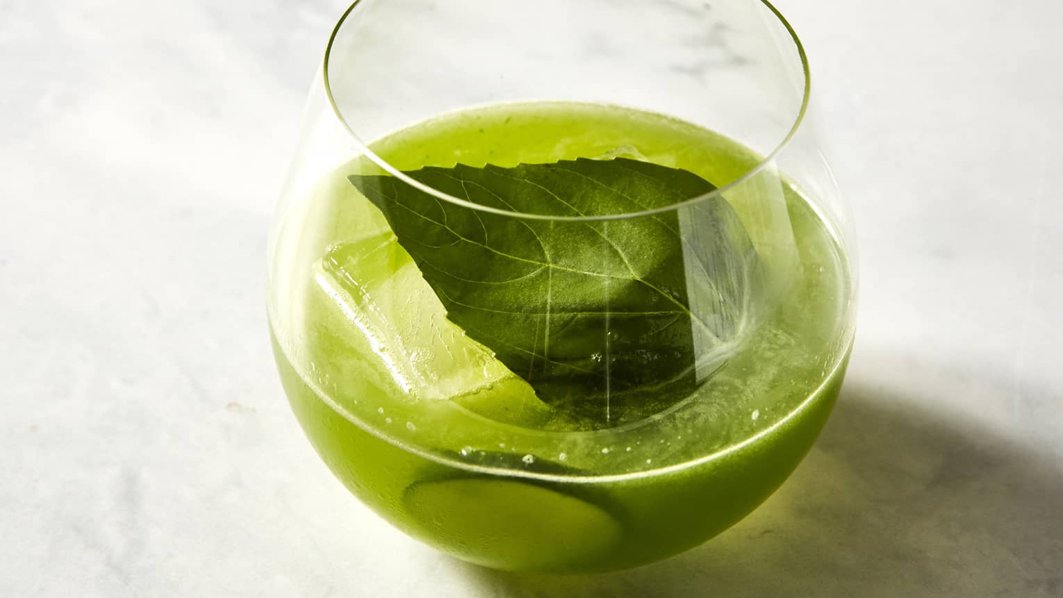 A green beverage with mint and lime. 
