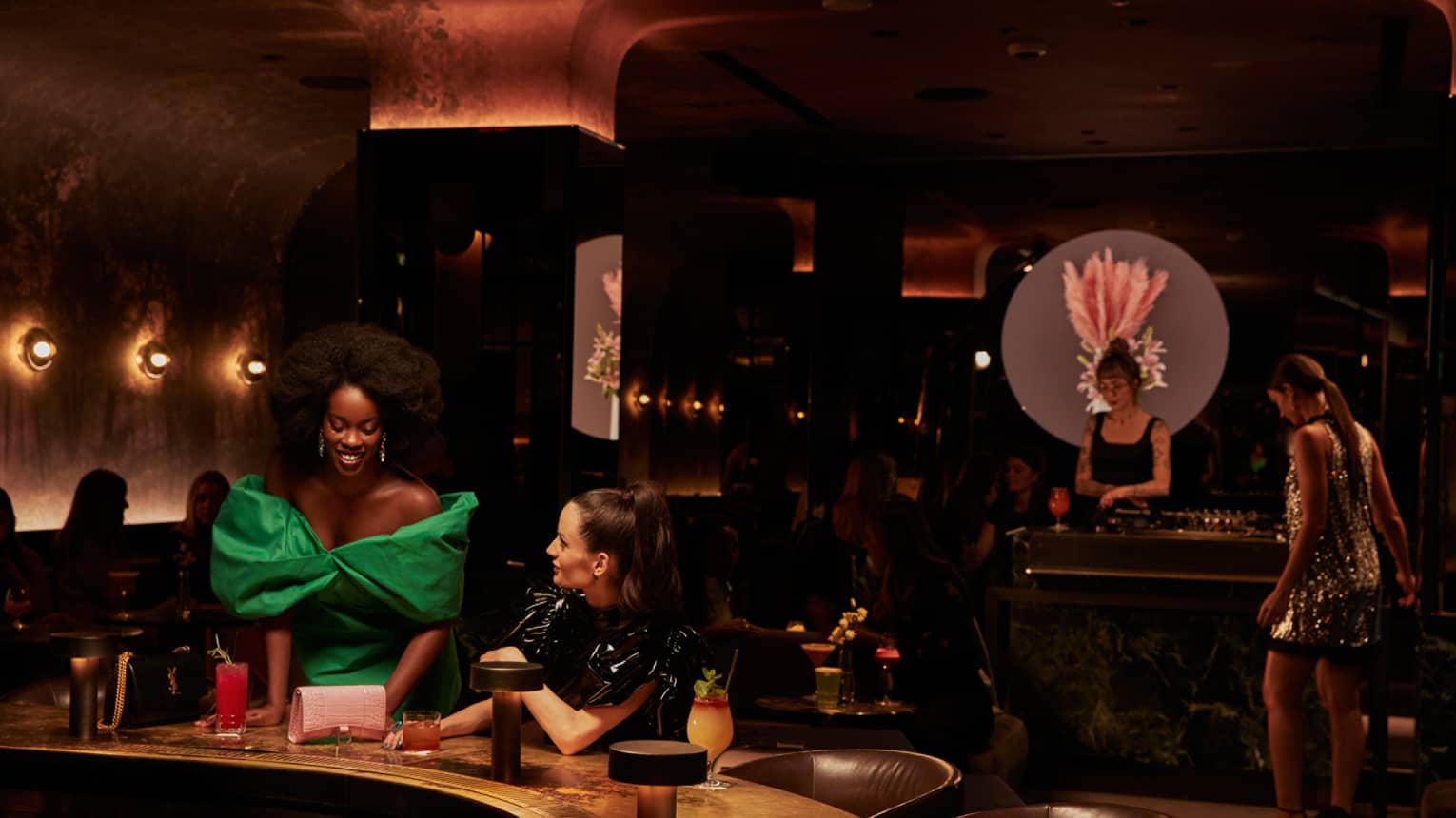 Two women in dresses at a bar.