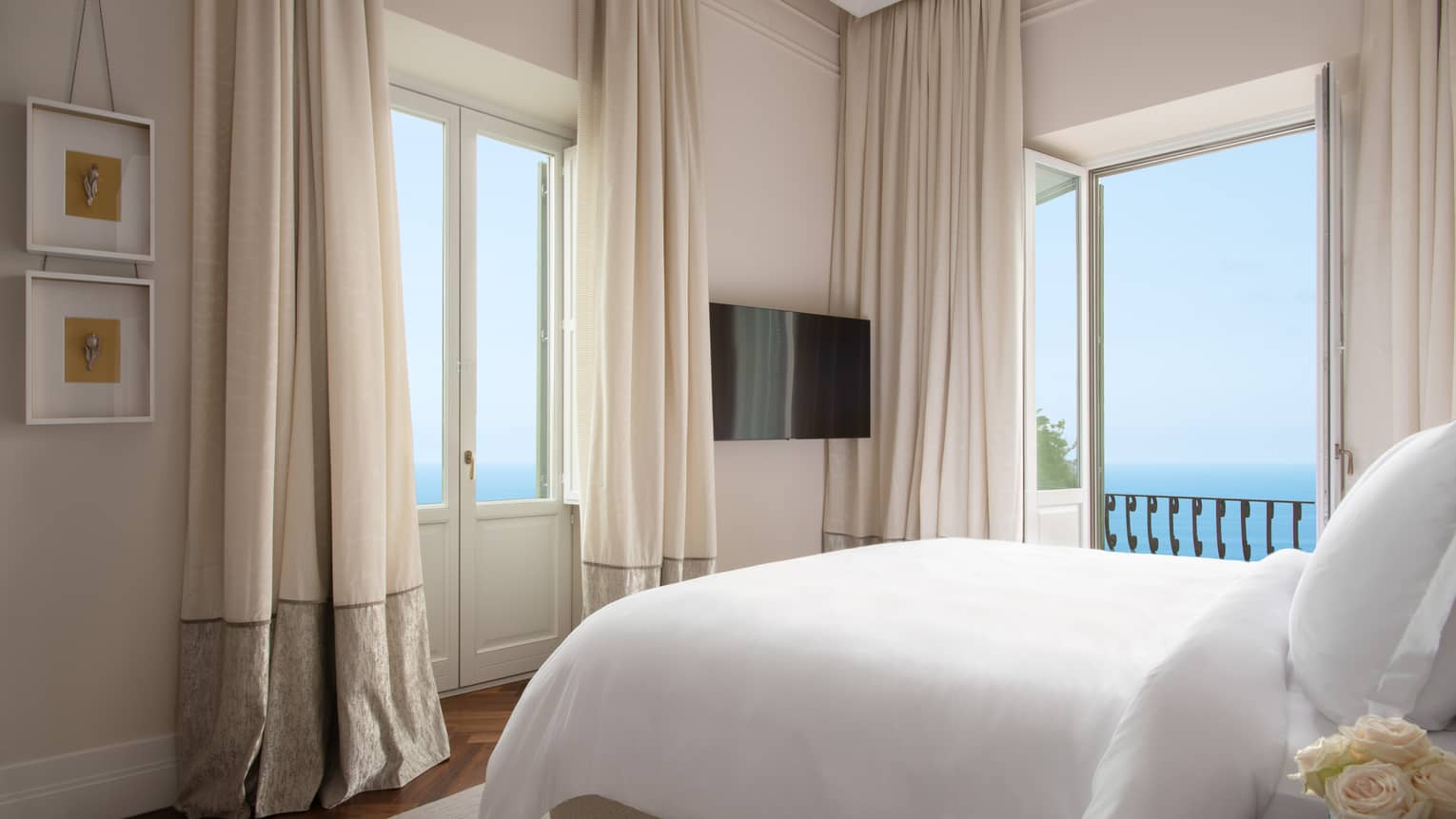 Bedroom with two sets of doors leading to ocean-view balcony