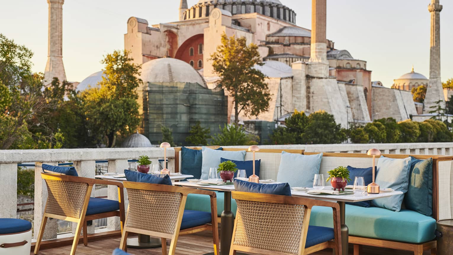 Terrace with outdoor table and blue cushioned chairs and the Blue Mosque in the background