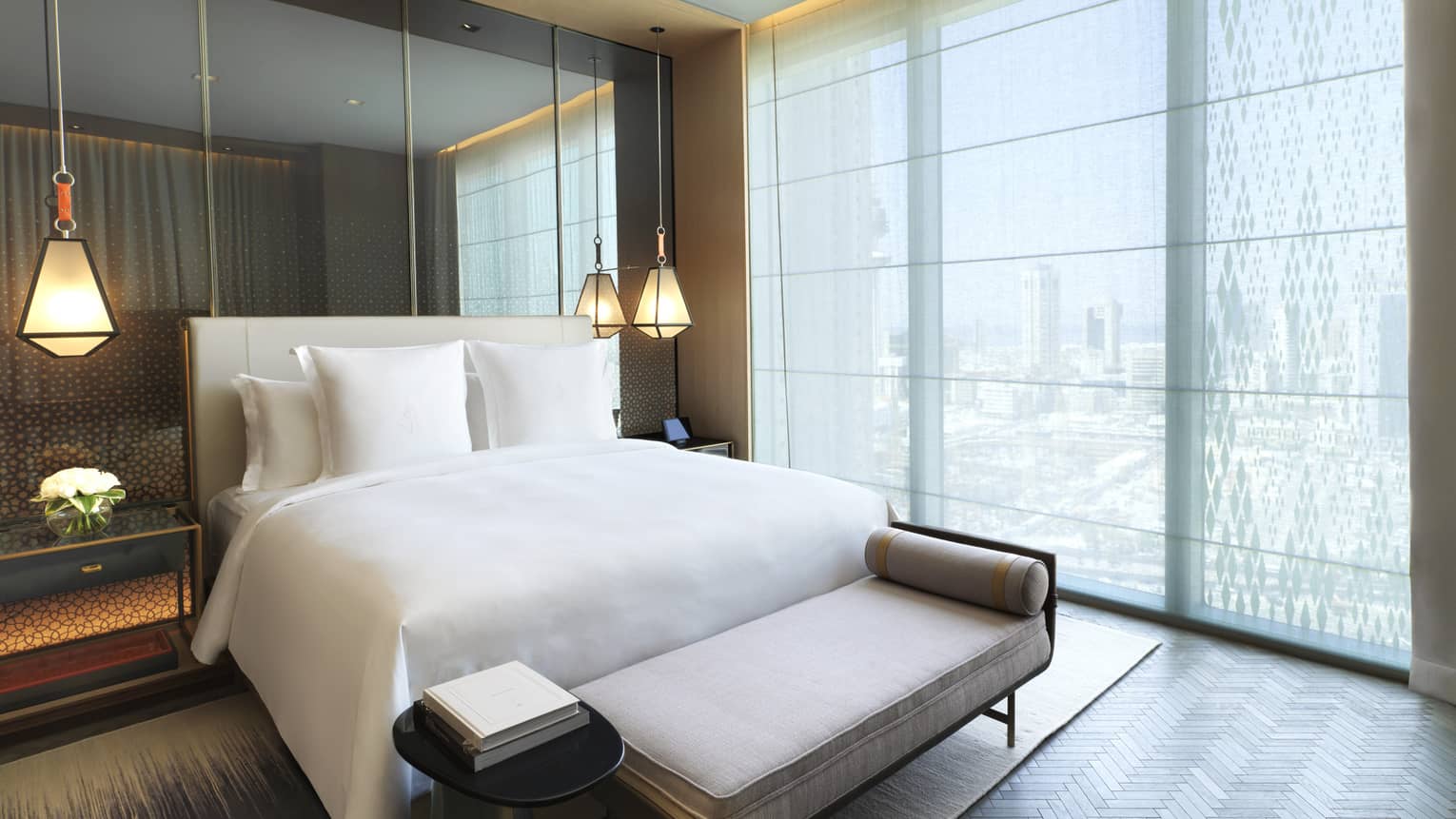 Four Seasons Executive Suite bed in front of mirror wall, hanging lights, beside floor-to-ceiling window