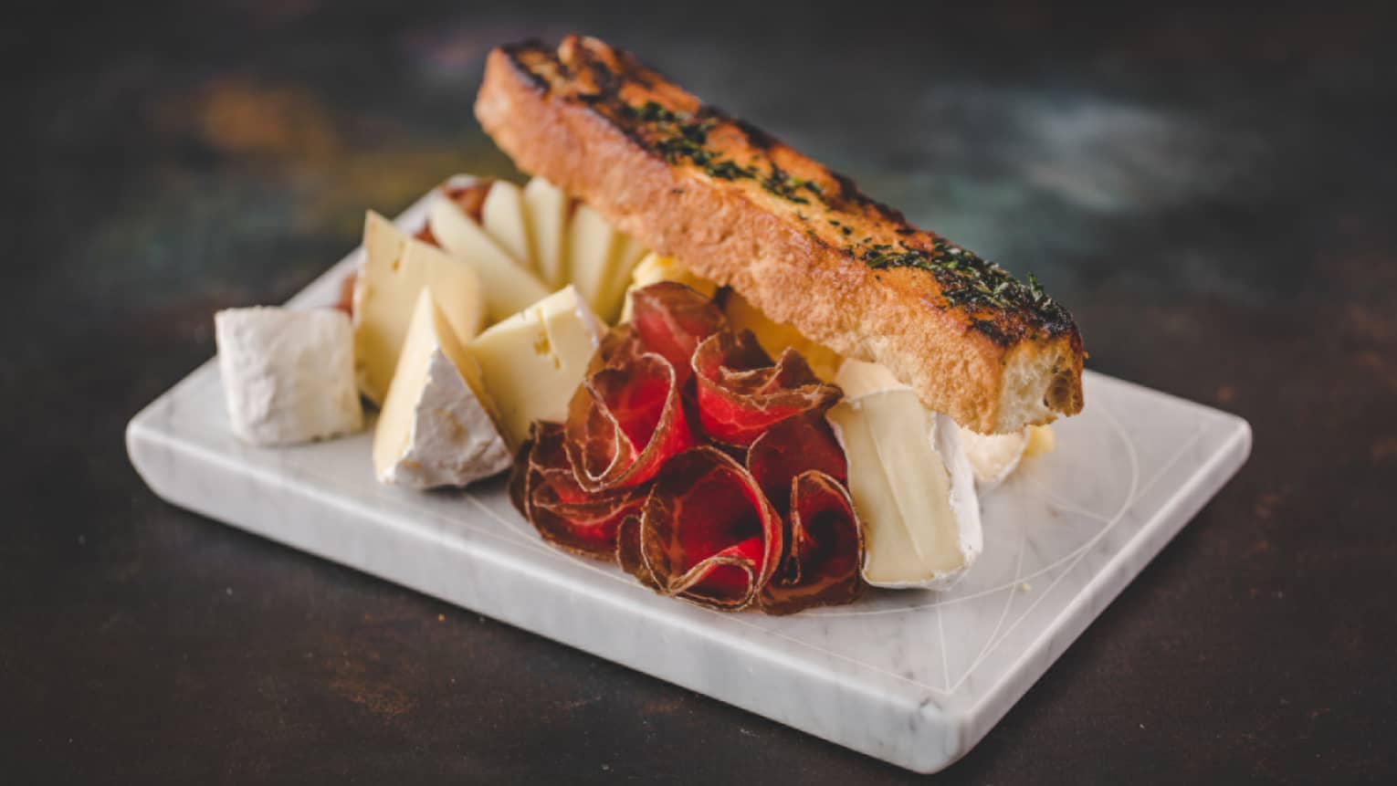 A fish filet served with a variety of cheeses.