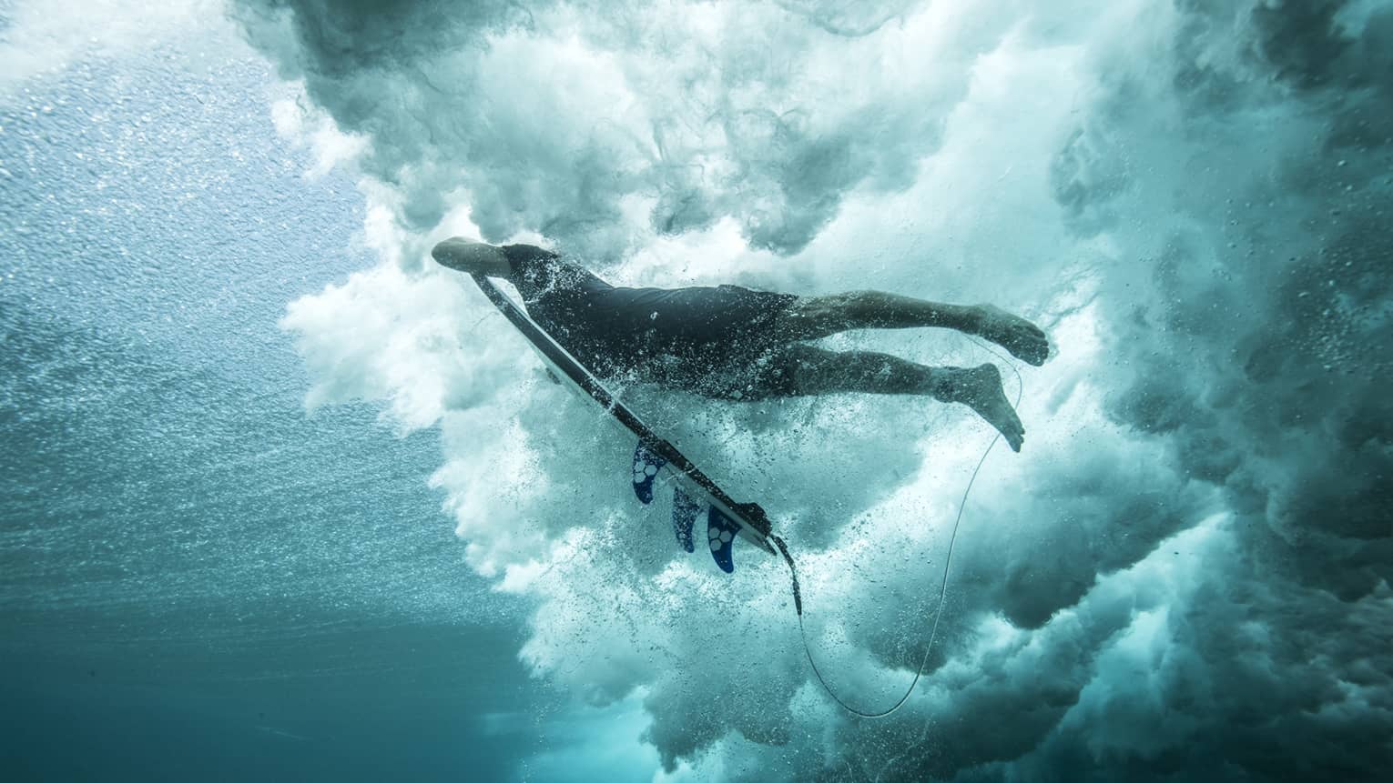 Angled shot of Tropicsurf pro breaking the surface of a wave 