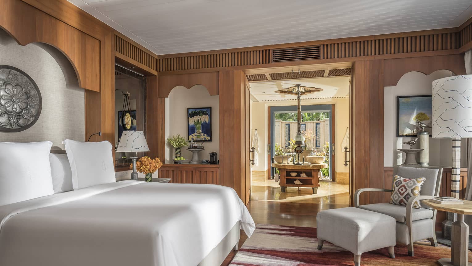 Lower Pavilion Room with white bed and gray club chair