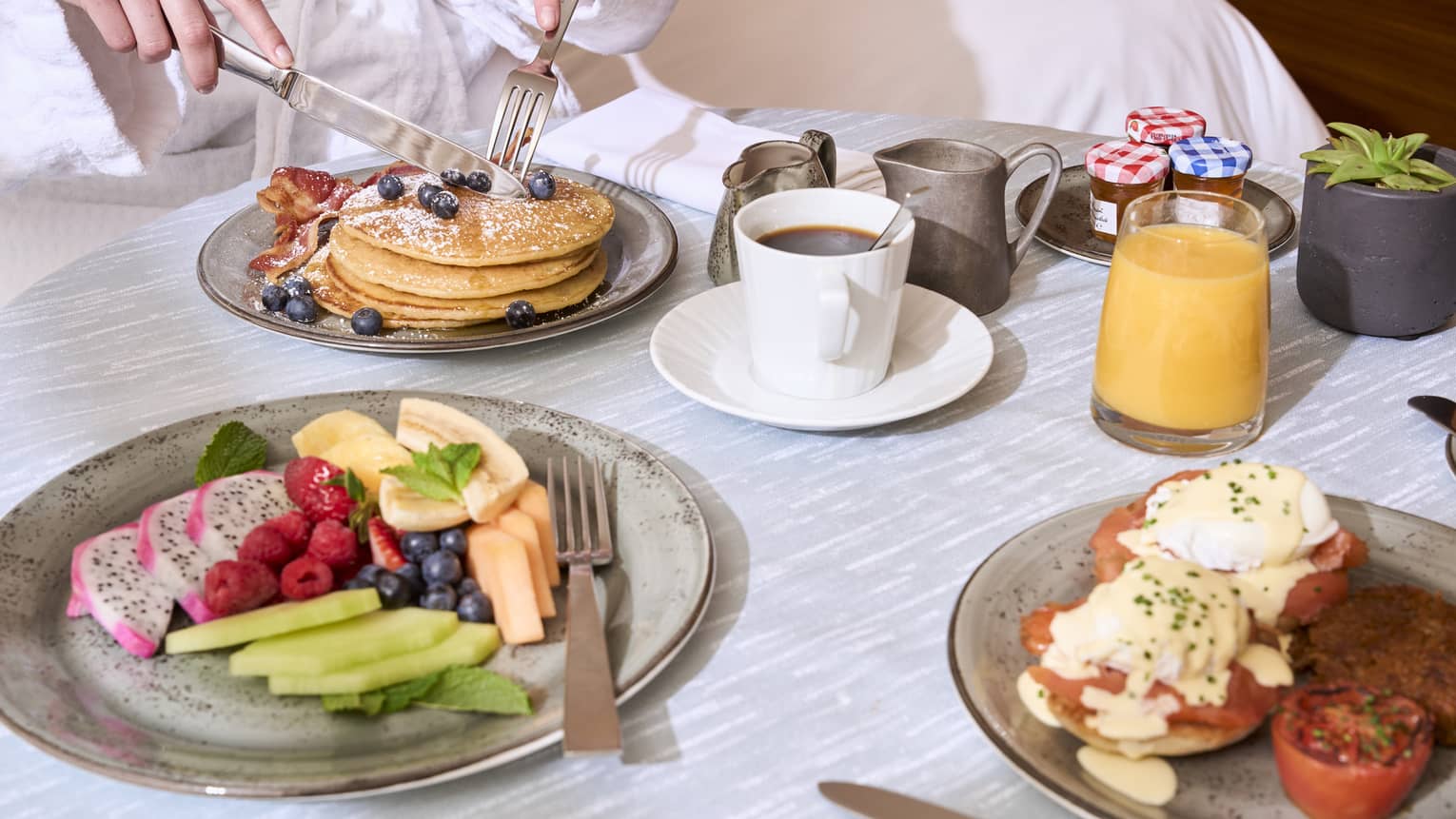 An assortment of breakfast food on a light grey table.