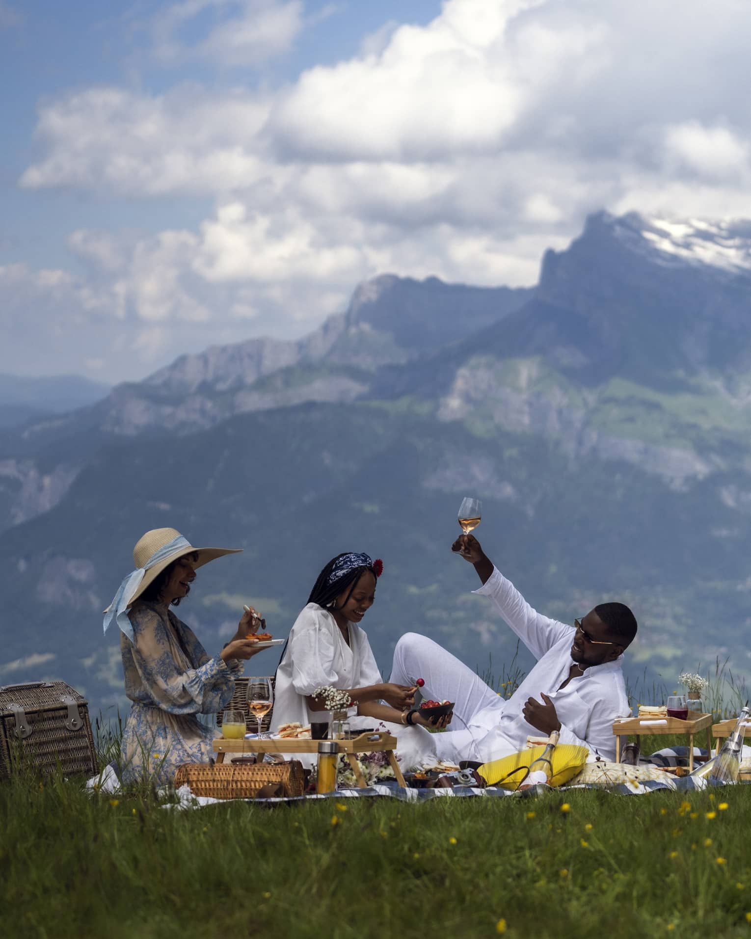 Three people enjoy gourmet picnic with ros� in French Alps
